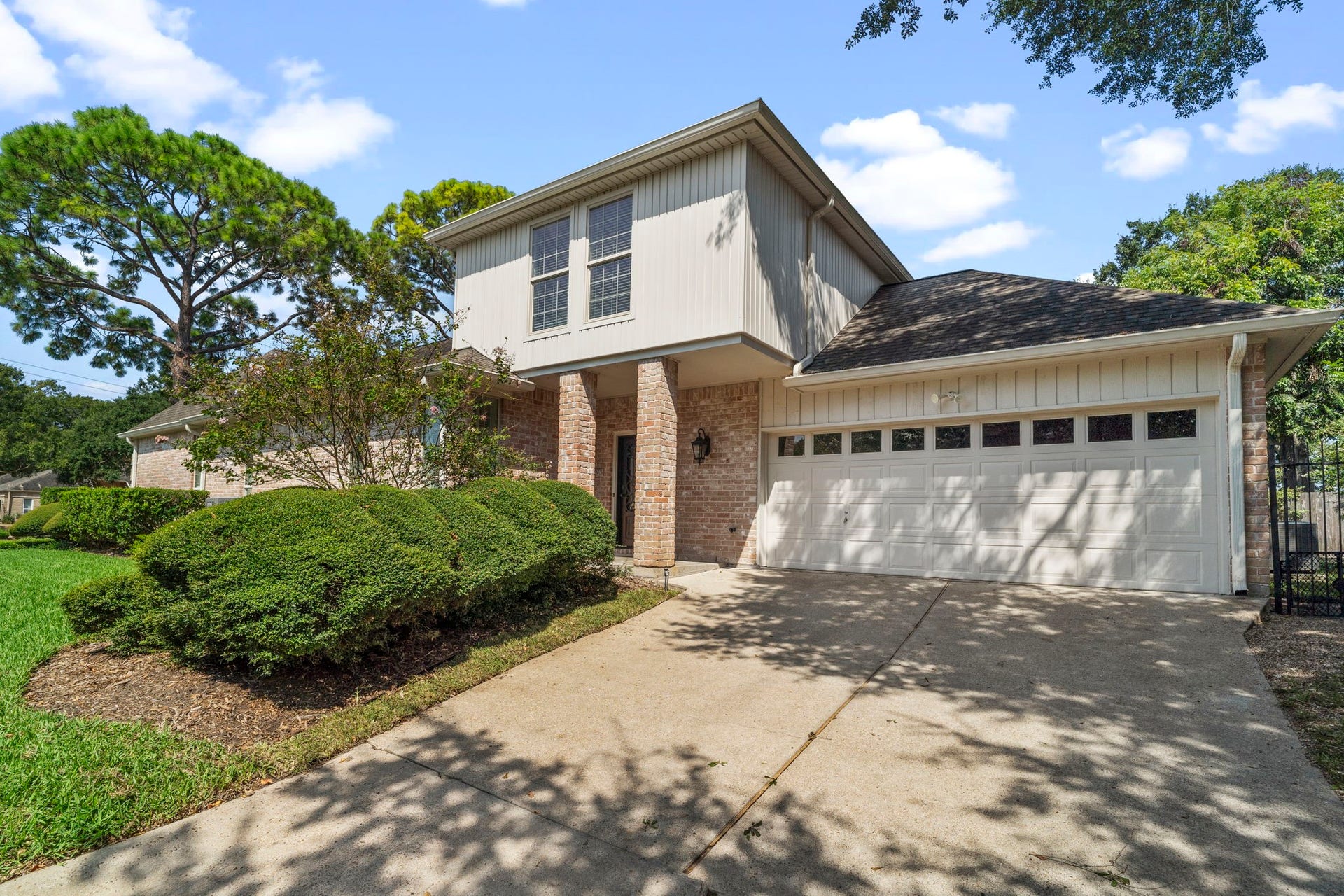 443 Fox Briar Lane, Sugar Land, TX 77478 A double-wide side-entry driveway leads to a freshly painted two-car garage, complete with built-in shelving and a work table.