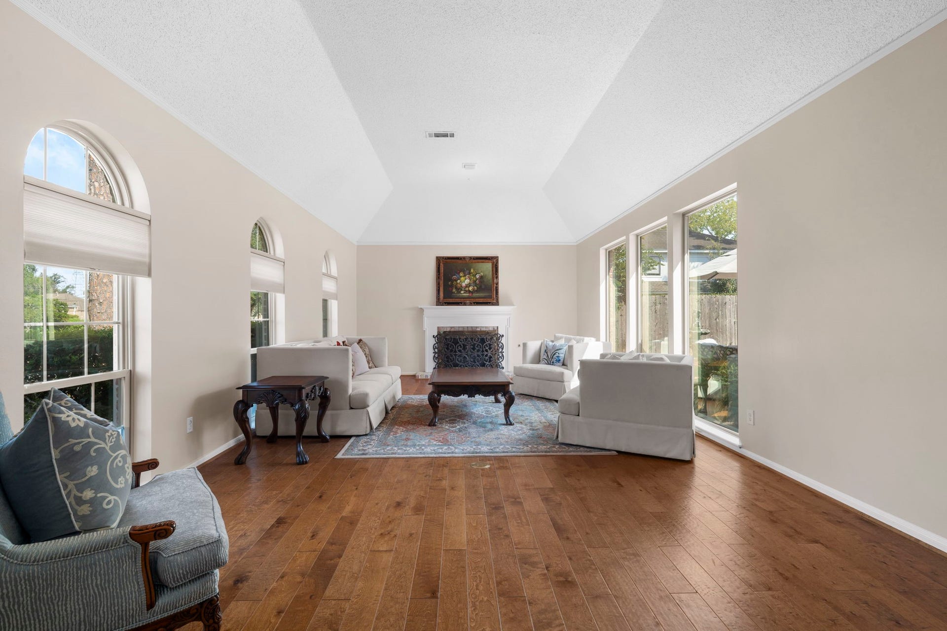 443 Fox Briar Lane, Sugar Land, TX 77478 Soaring ceilings, expansive courtyard-facing windows, and a stately fireplace define the spectacular living room.