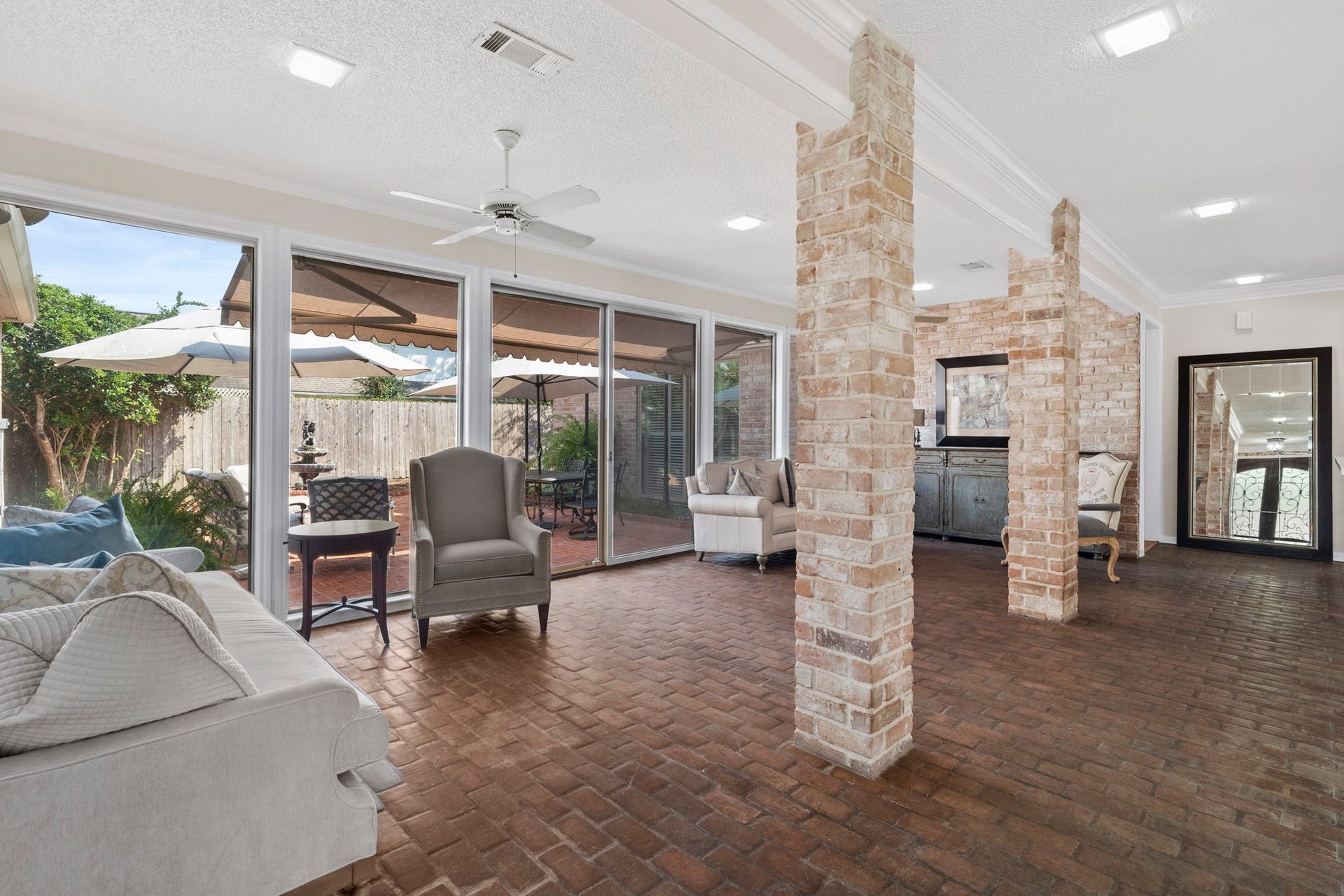 443 Fox Briar Lane, Sugar Land, TX 77478 The living room has the light-filled feel of a sunroom, with a wall of windows and a sliding glass door creating a seamless connection to the outdoor living space.