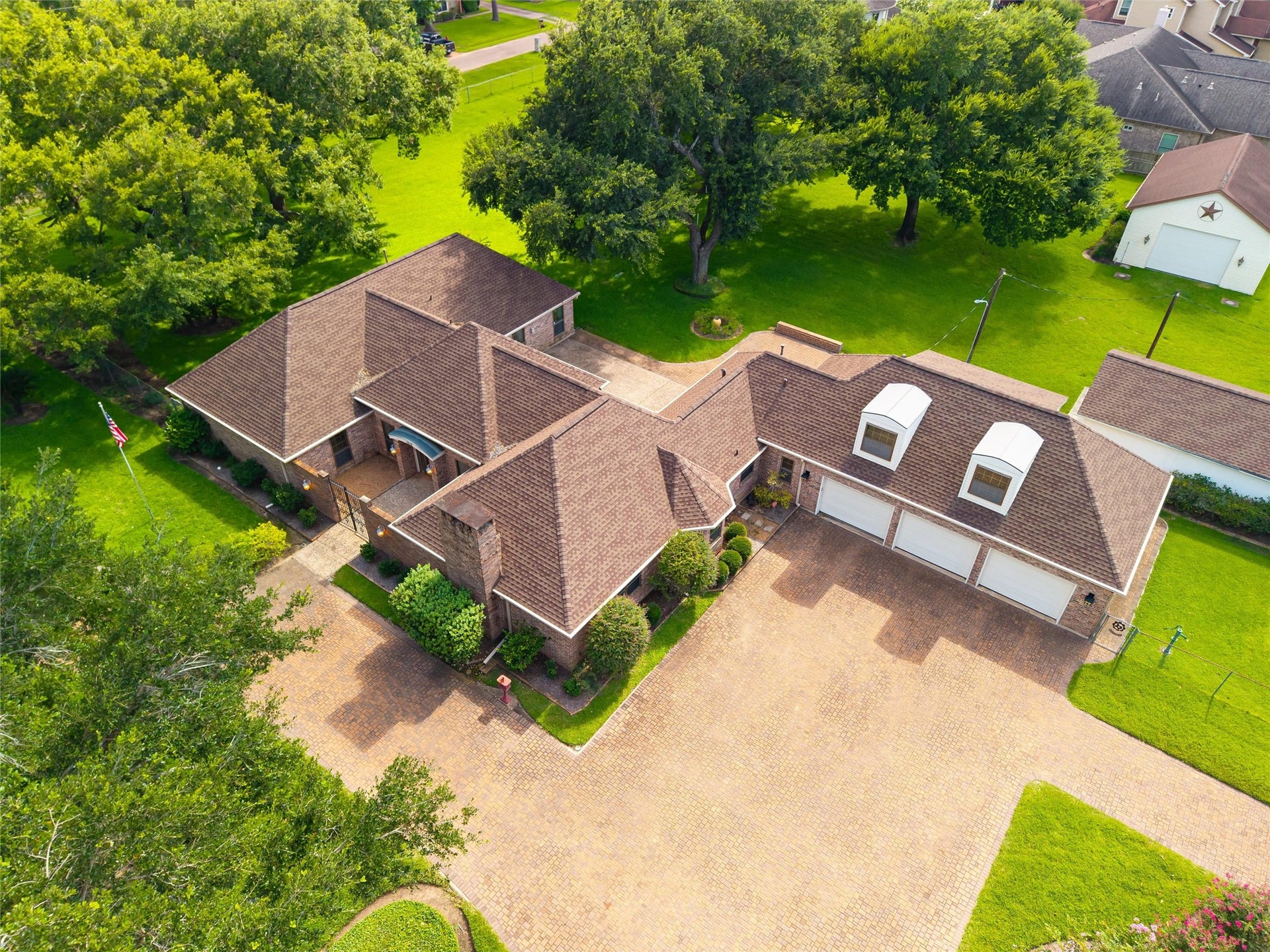 1715 Avenue D, Katy, TX 77493 A bird's-eye view captures the scale of the estate, showcasing the newer roof, detached barn and workshop, winding paved drives, magnificant oaks and meticulously manicured grounds.