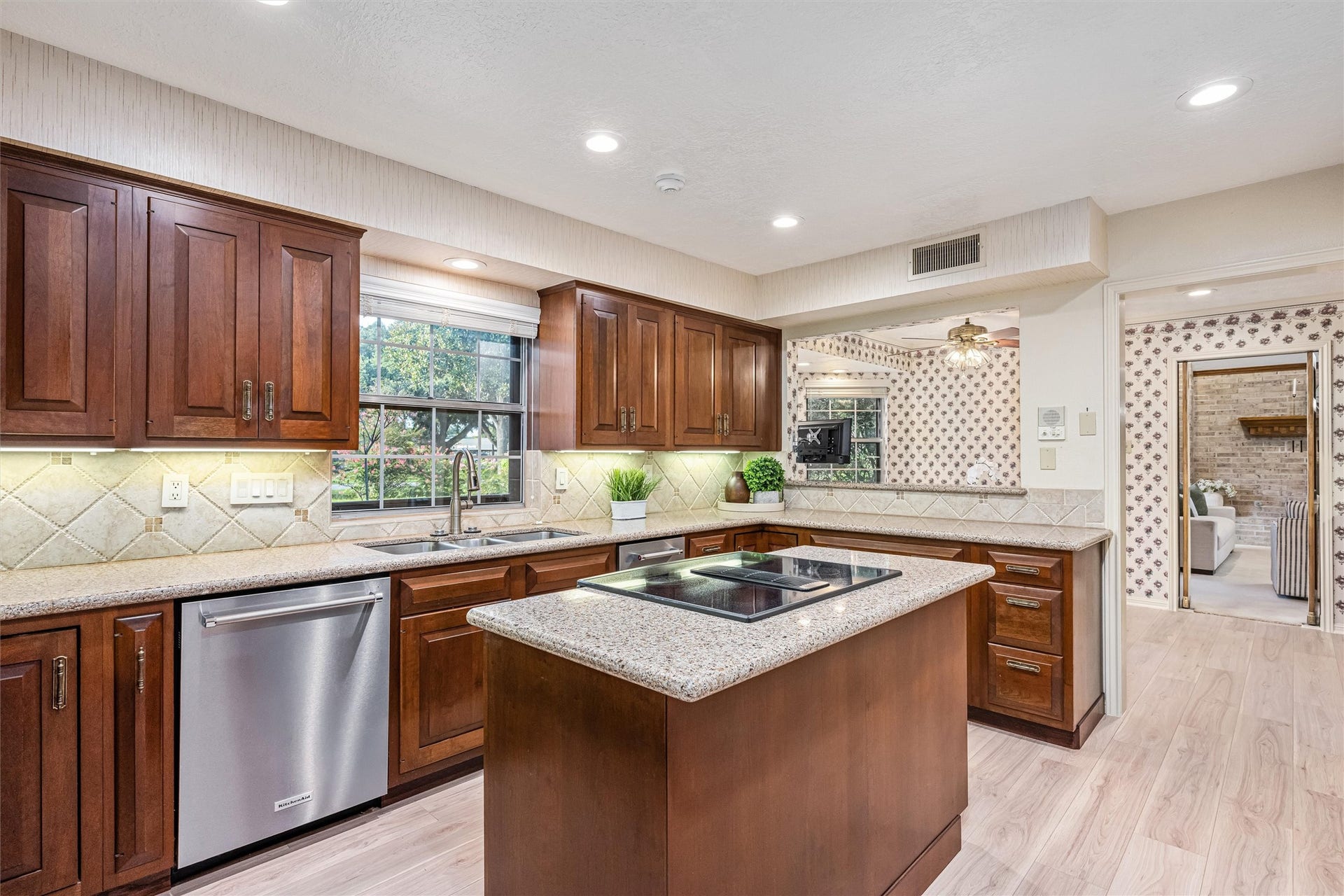 1715 Avenue D, Katy, TX 77493 Big and bright kitchen window fills the room with natural light, complementing quartz countertops, a JennAir cooktop and a new built-in ice maker!