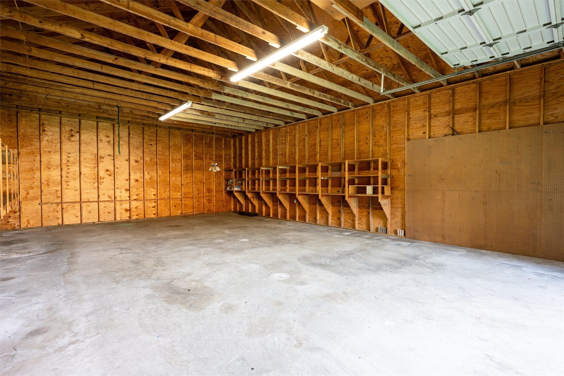 1715 Avenue D, Katy, TX 77493 Inside, soaring ceilings and shelving along both sides maximize the barn's expansive open interior, offering exceptional storage and potential space for an RV.