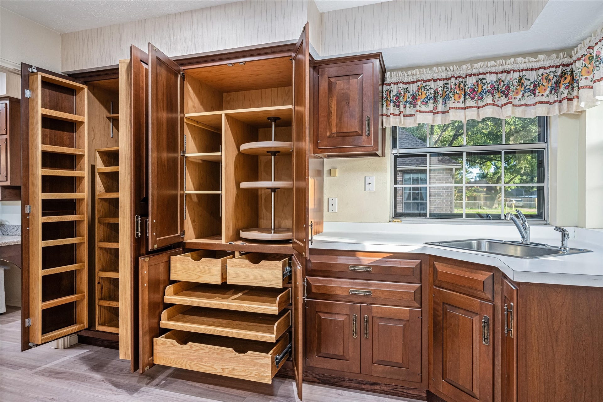 1715 Avenue D, Katy, TX 77493 Professionally designed custom built-in pantry organization includes pull-out shelving with additional hidden storage, specialized organizers, rollout drawers and Lazy Susans. Utility room offers a dedicated utility sink, extensive cabinetry and windows overlooking your spectacular back yard.
