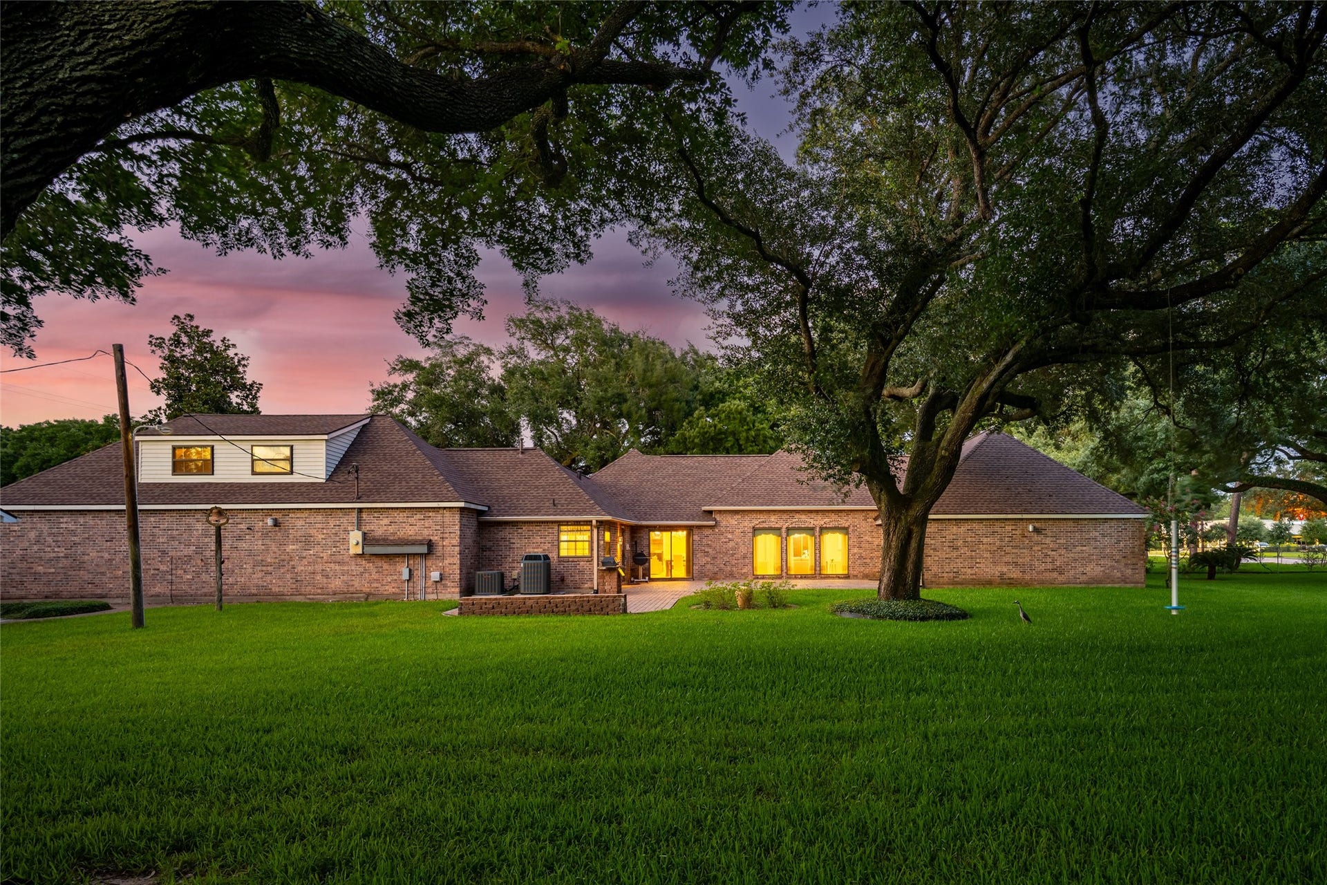 1715 Avenue D, Katy, TX 77493 As evening falls, the graceful canopy of iconic oaks frames the estate in timeless beauty. Don't miss the heron that graced our presence!