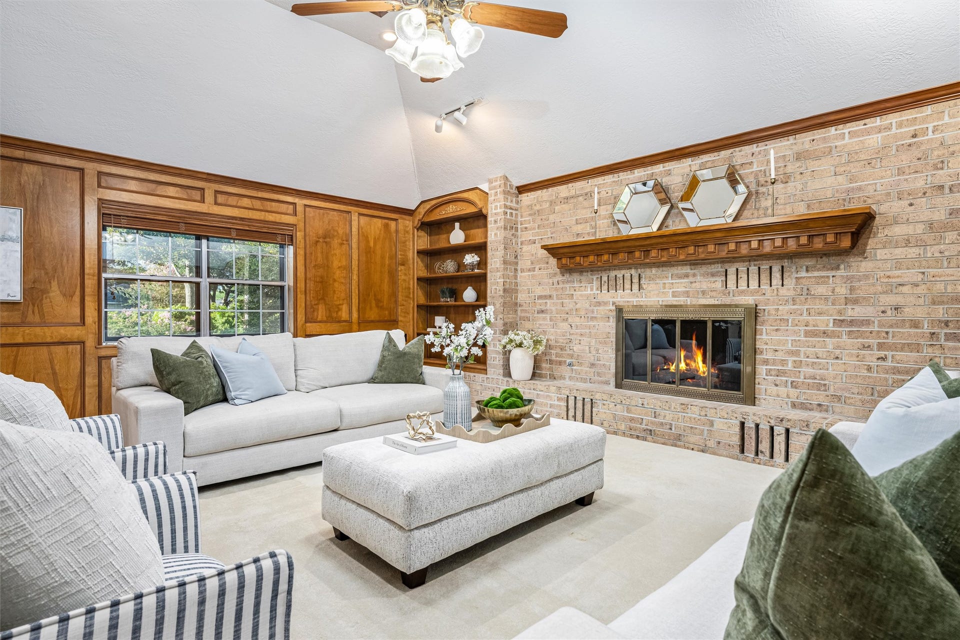 1715 Avenue D, Katy, TX 77493 Warm, inviting family room featuring rich wood paneling, custom built-ins, vaulted ceilings and a gas fireplace with Heatilator system for cozy winter evenings!