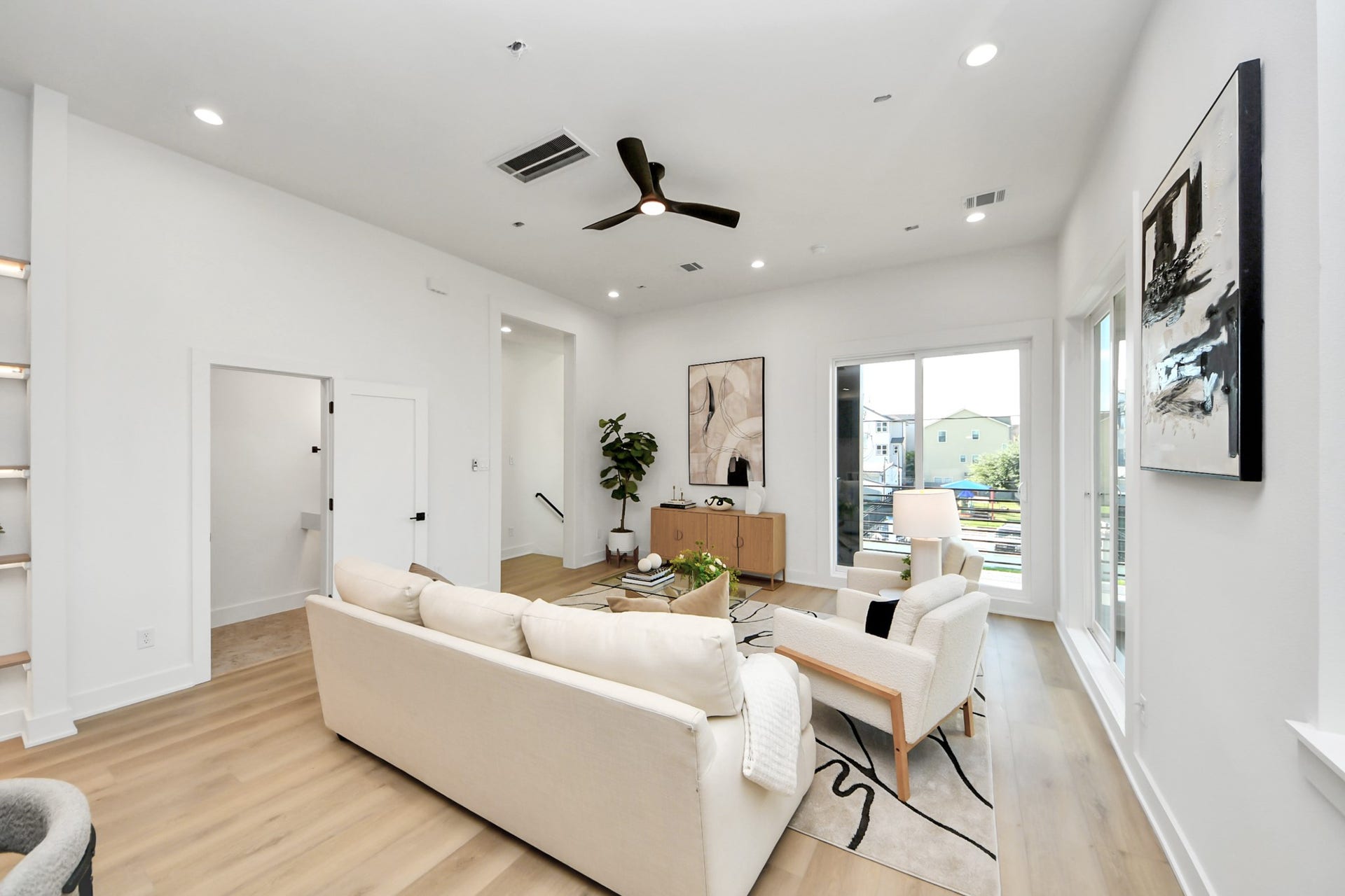 1603 W 25th Street, Houston, TX 77008 Bright living room featuring modern seating, oversized windows, and access to the private balcony.