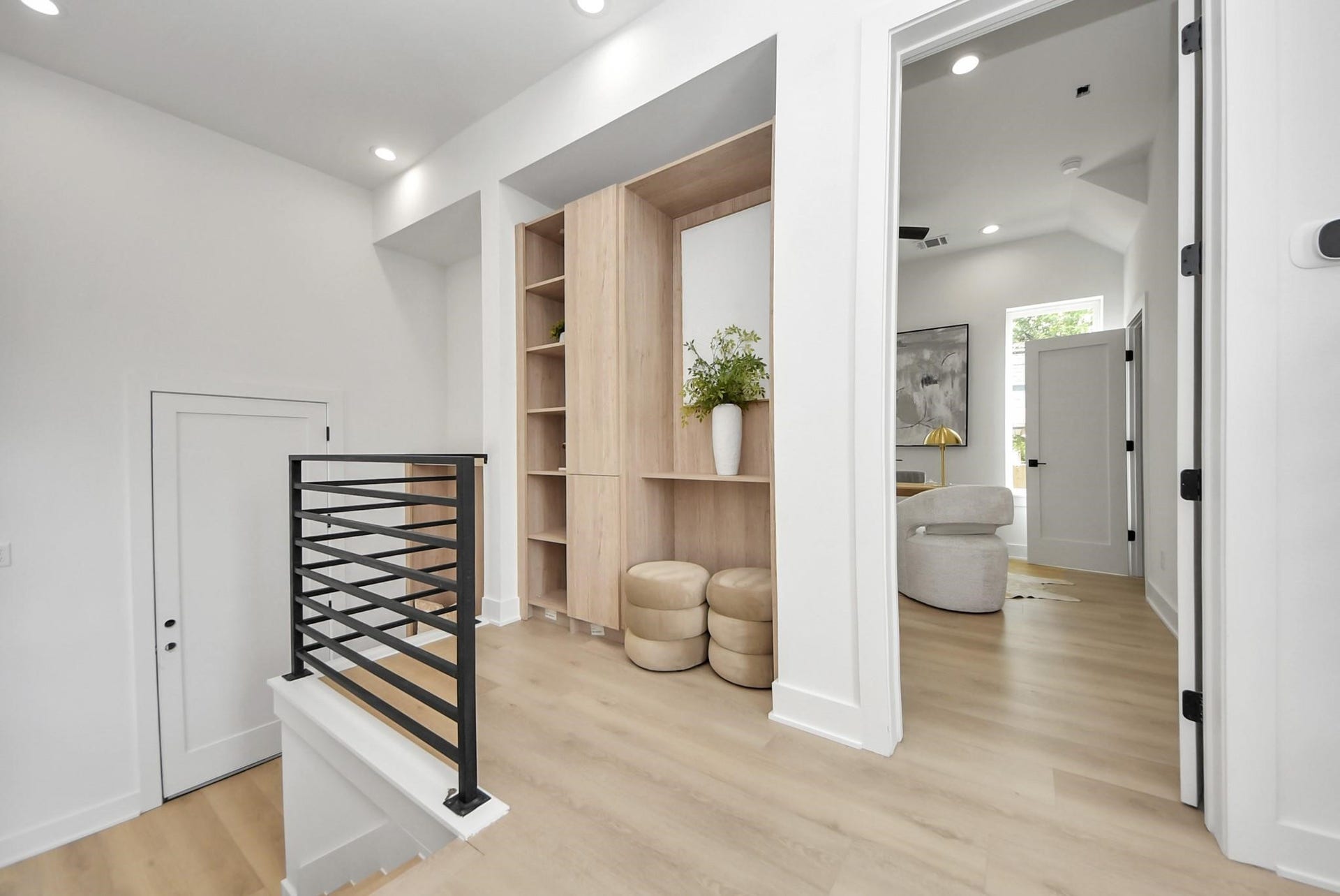 1603 W 25th Street, Houston, TX 77008 Upper landing showcasing light wood flooring, built-in storage, and access to the adjacent office.