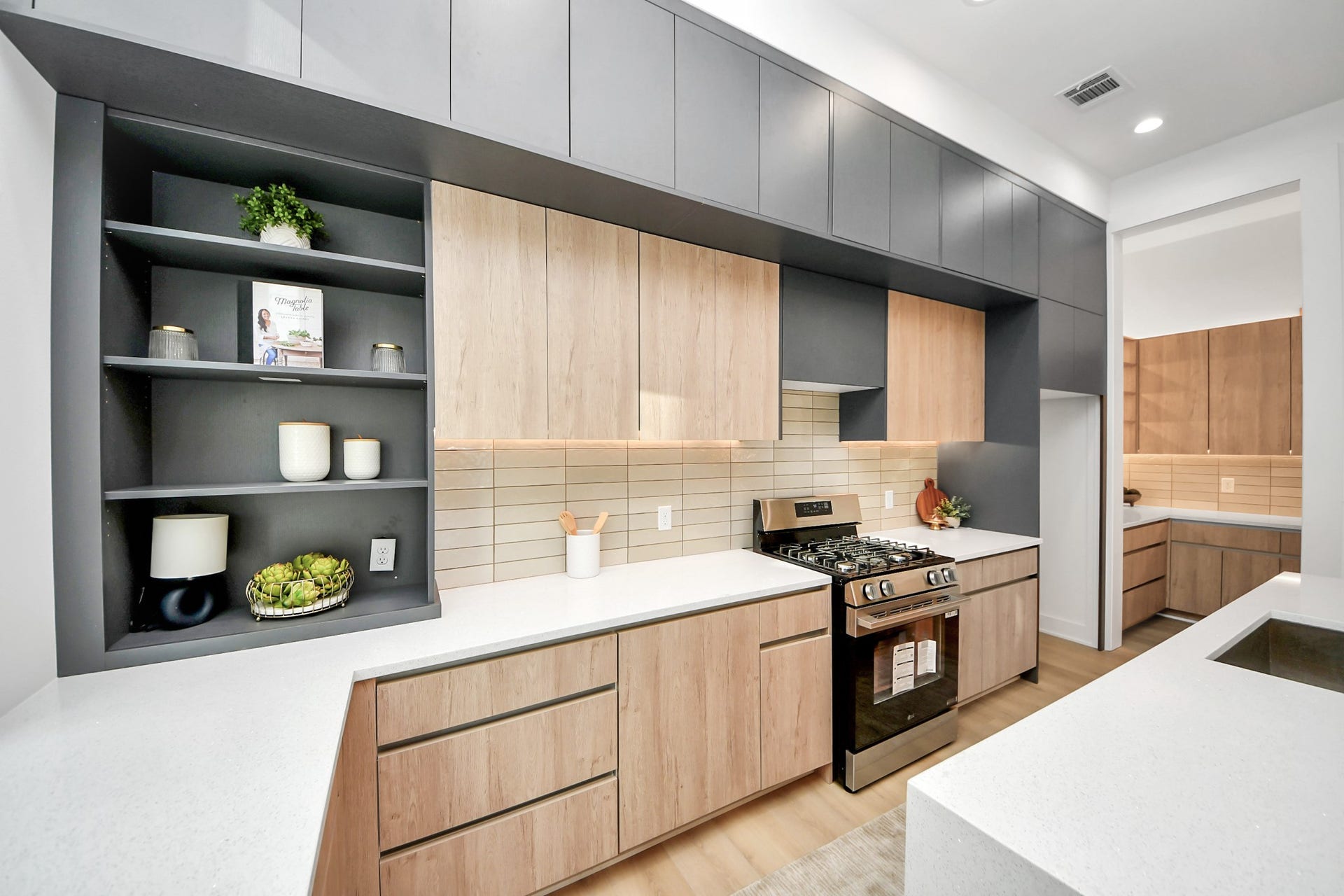 1603 W 25th Street, Houston, TX 77008 Bright kitchen with expansive windows, quartz countertops, open display shelving, and stainless steel appliances.