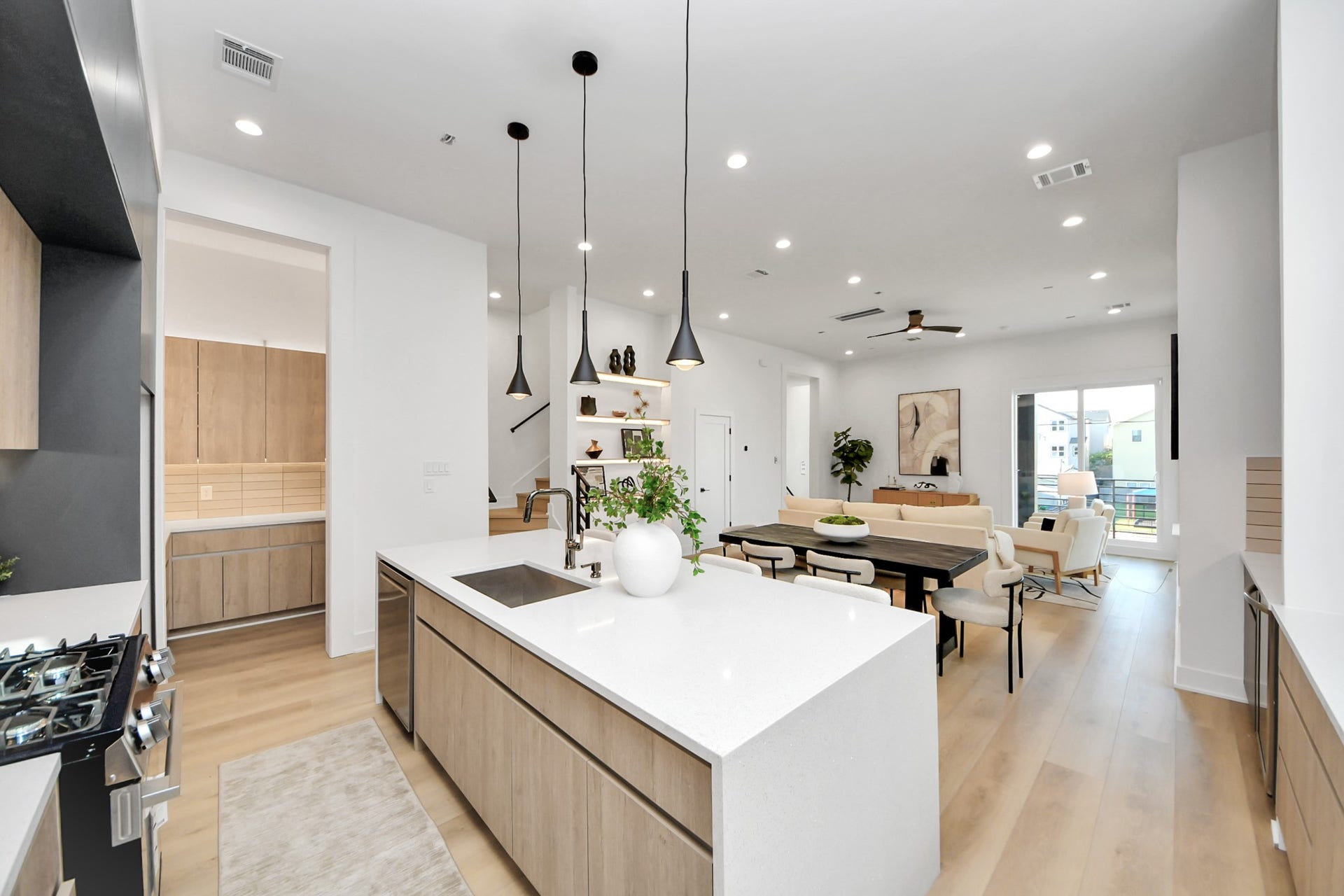 1603 W 25th Street, Houston, TX 77008 Chef-inspired kitchen featuring a gas range, large island with sink, pendant lighting, and walk-in pantry.