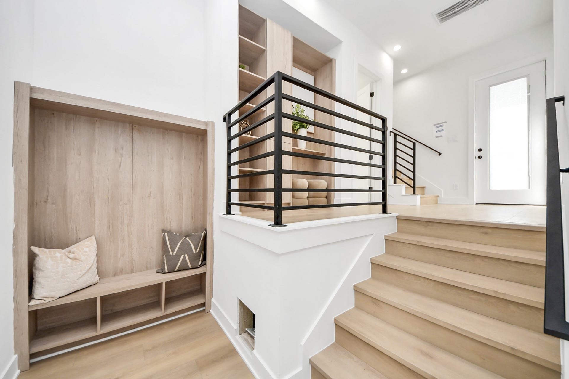 1603 W 25th Street, Houston, TX 77008 Stylish stair landing featuring sleek black railings and custom built-in storage.