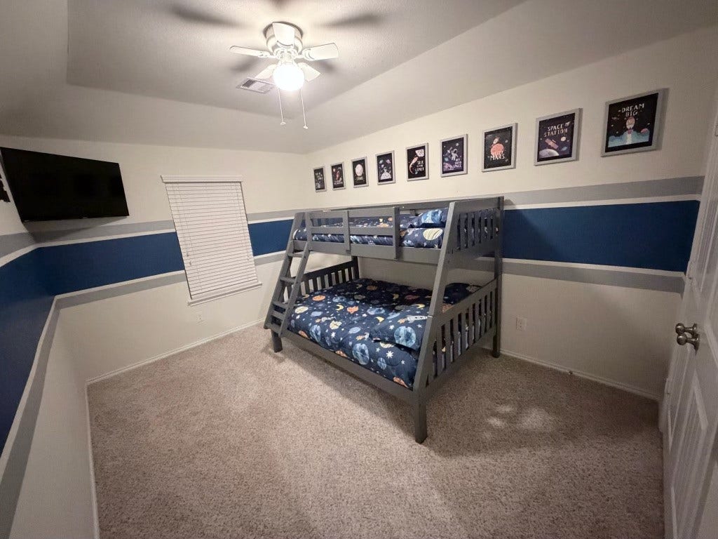2806 Bretton Woods Drive, Conroe, TX 77301 Discover the spacious 13x15 upstairs second bedroom, perfect for creativity and comfort, featuring playful decor and ample natural light.