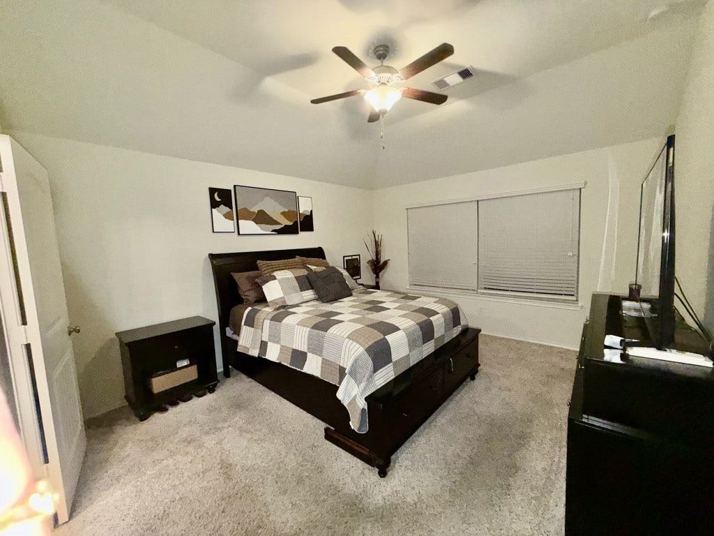 2806 Bretton Woods Drive, Conroe, TX 77301 Experience comfort and style in this spacious 13x15 primary suite, featuring a cozy, carpeted floor, modern ceiling fan, and ample natural light.