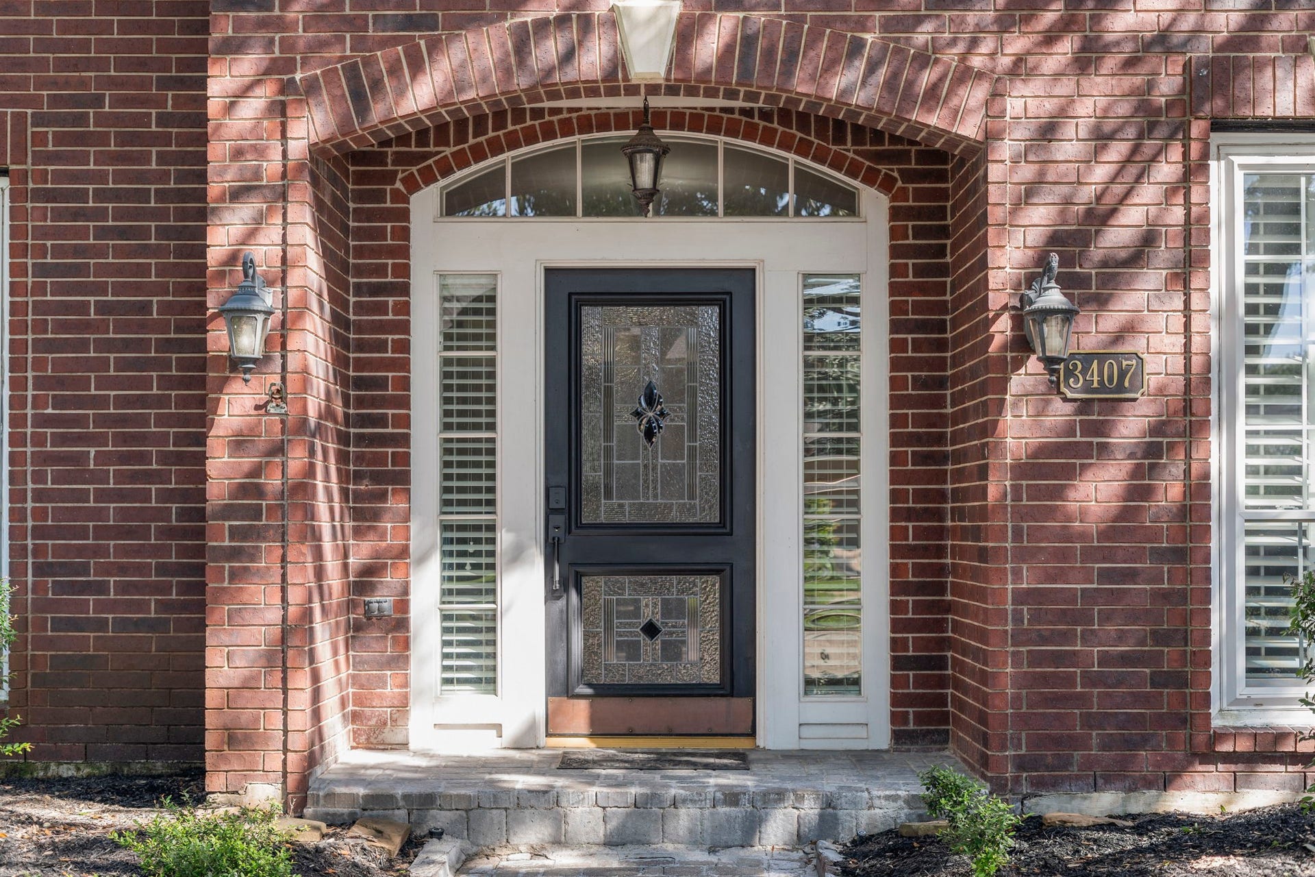 3407 Autumn Bend Drive, Sugar Land, TX 77479 A gorgeous custom wood and leaded glass front door with sidelights and an arched transom window welcomes guests inside.