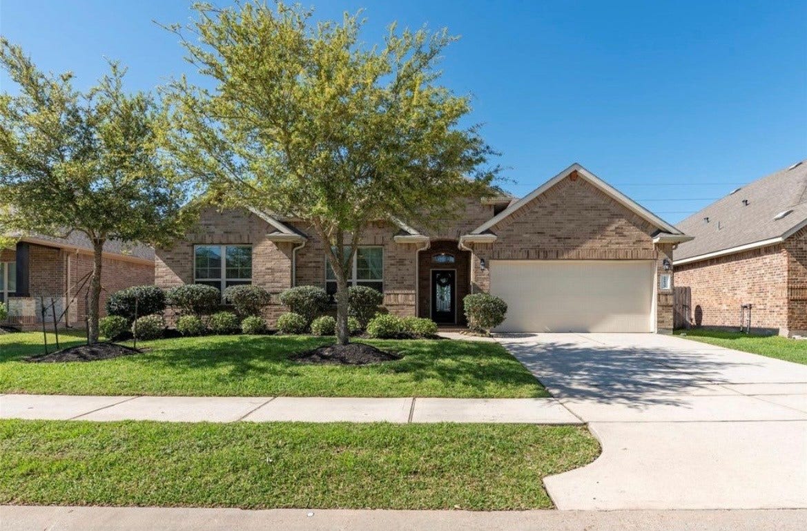 22939 Banff Brook Way, Tomball, TX 77375 Charming brick home with a welcoming front yard, mature trees, and a double garage, offering excellent curb appeal.