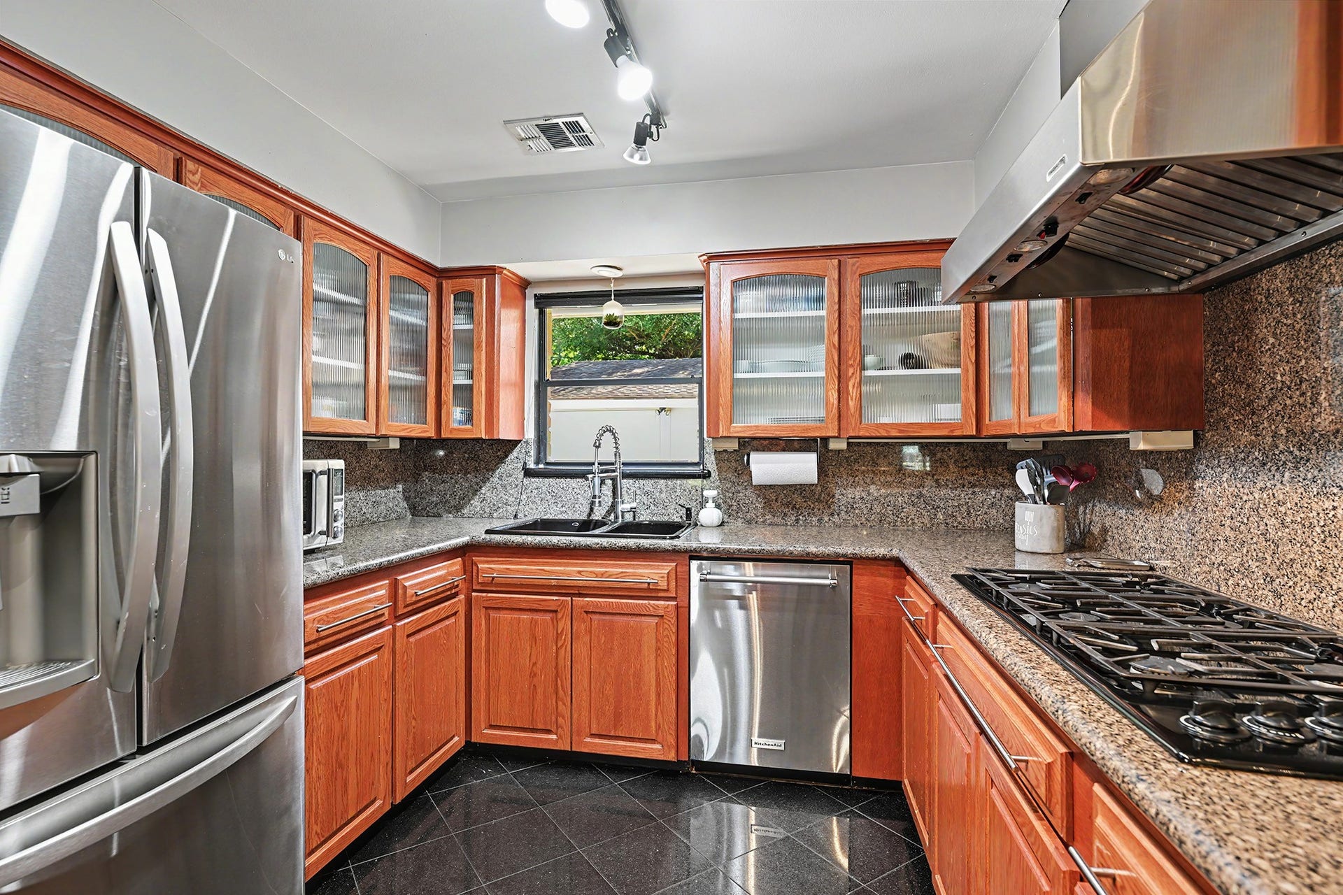 Granite counters and backsplash.  6-burner gas cooktop with vent hood.