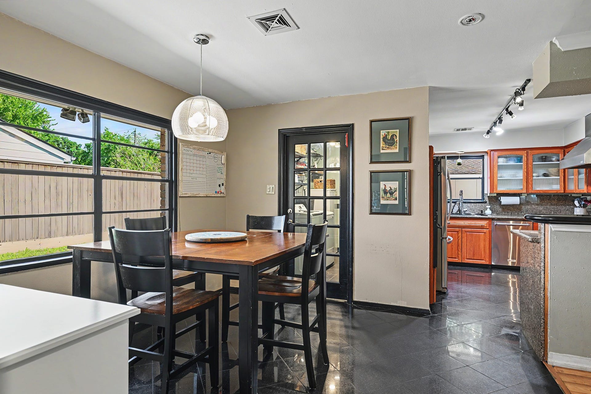 Spacious breakfast area with wall space for storage cabinets and door into utility room.
