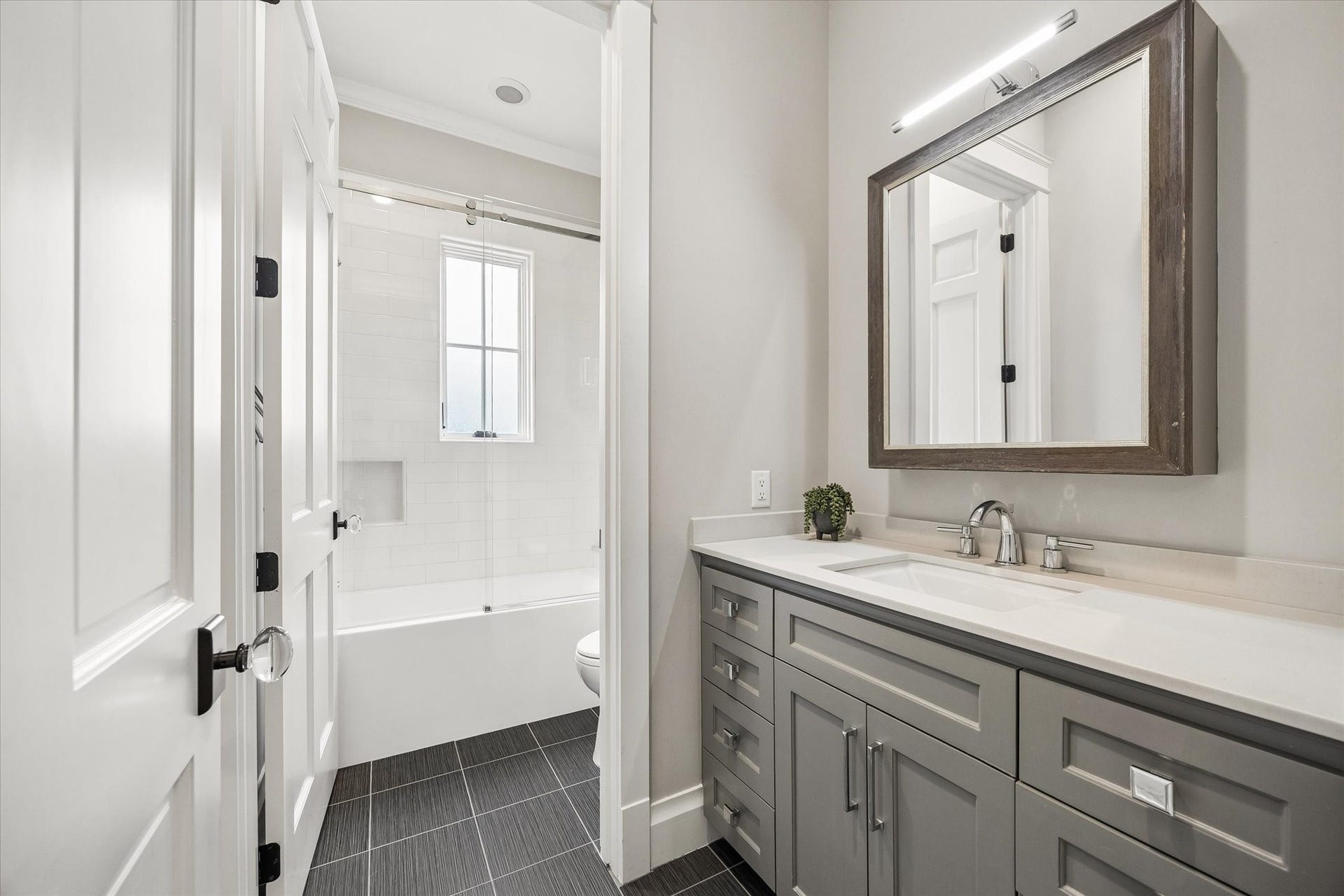 438 W 28th Street, Houston, TX 77008 The upstairs guest bathroom offers plenty of room to get ready for the day, with a spacious vanity, ample counter space and a private water closet with a tub and shower combination. Stylish tilework and modern finishes give the space a fresh, inviting feel.