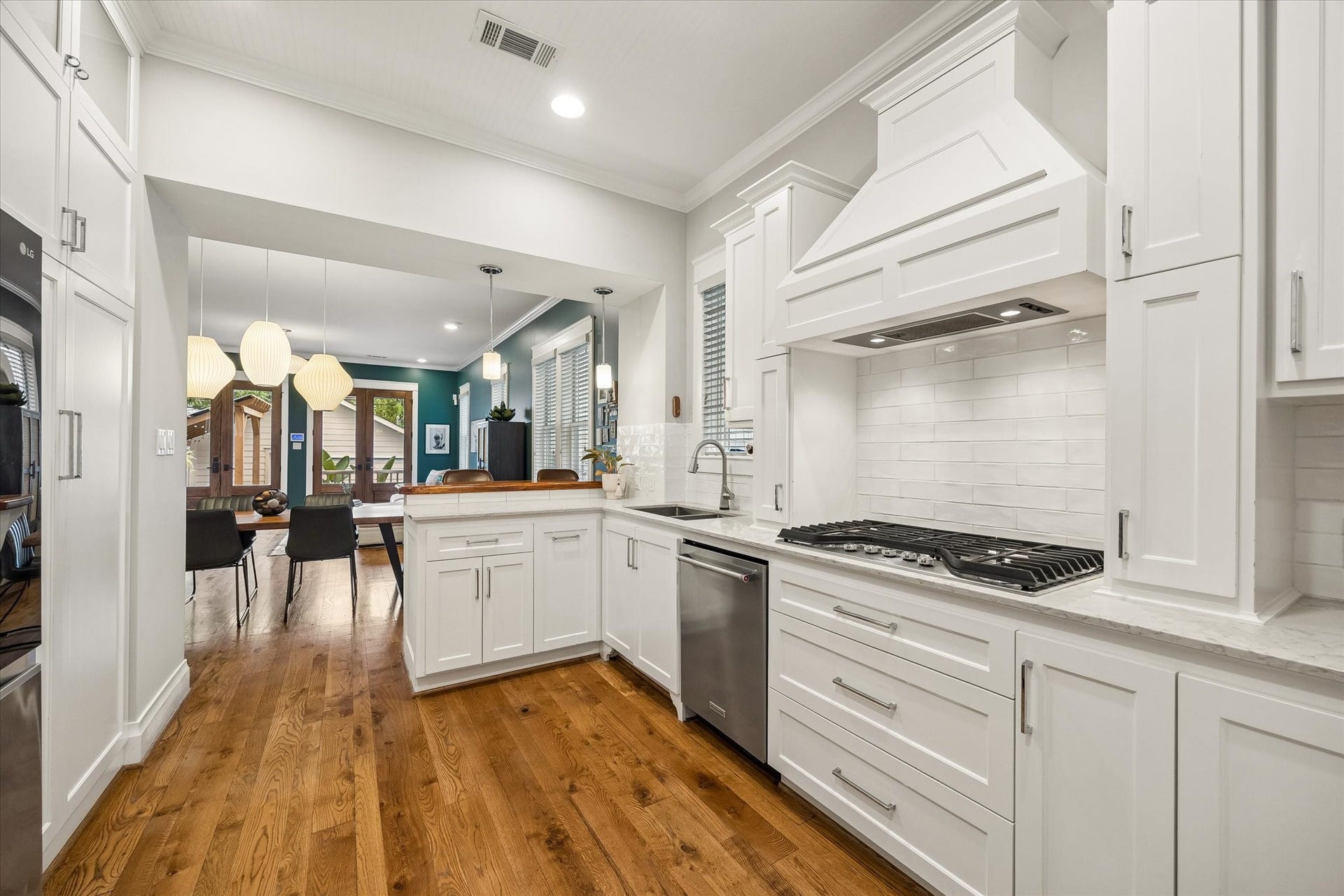 438 W 28th Street, Houston, TX 77008 There's plenty to love in this well-appointed kitchen! Custom cabinetry with modern pulls and soft-close drawers, a subway tile backsplash, under-cabinet lighting and a custom vent hood bring style and function together beautifully, while the open layout keeps you connected to the dining and family rooms.