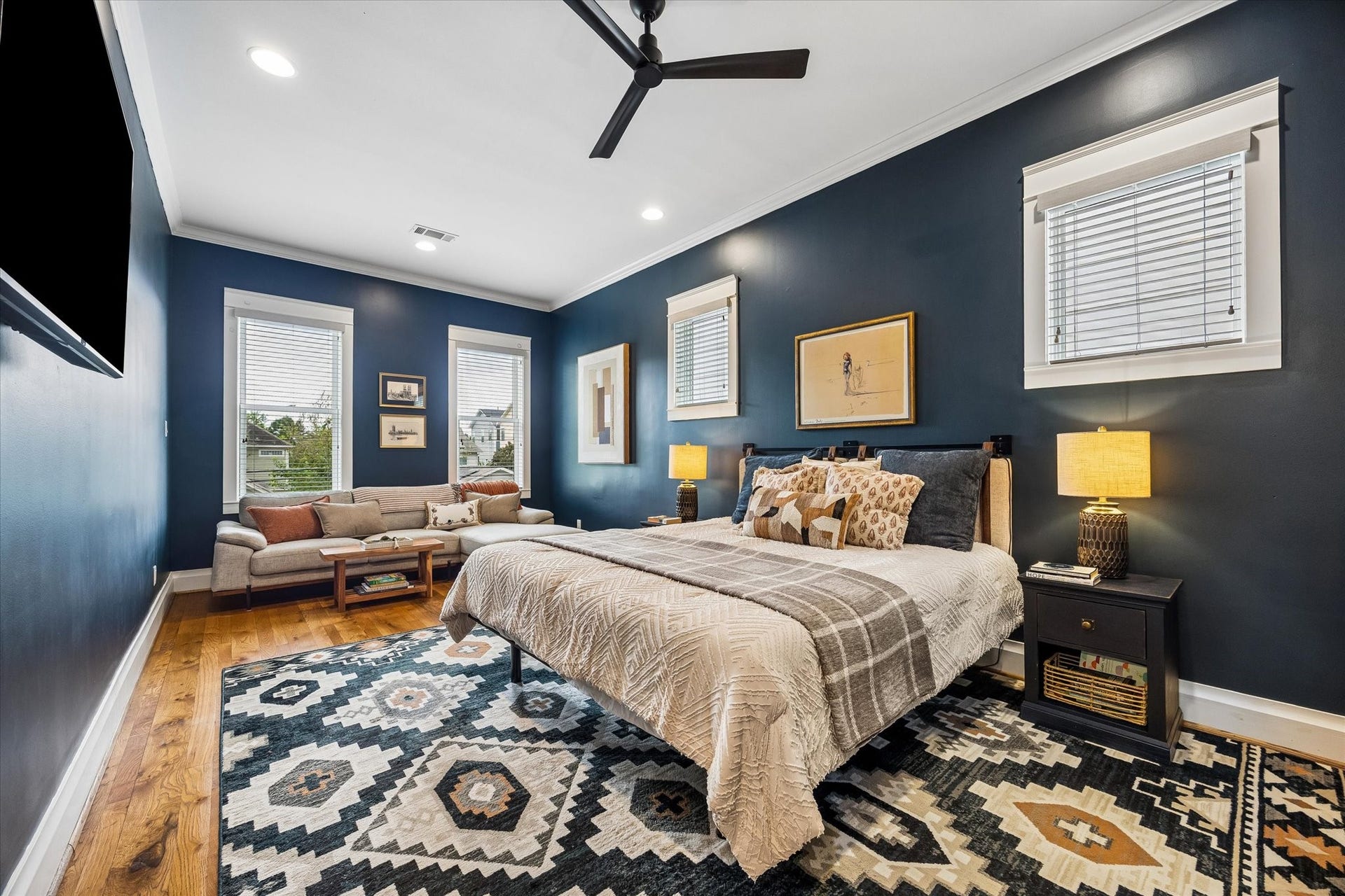 438 W 28th Street, Houston, TX 77008 Your own private retreat awaits! This spacious primary bedroom offers beautiful wood floors, rich designer paint, a sleek ceiling fan and plenty of natural light, with room to curl up with a good book or unwind after a busy day.