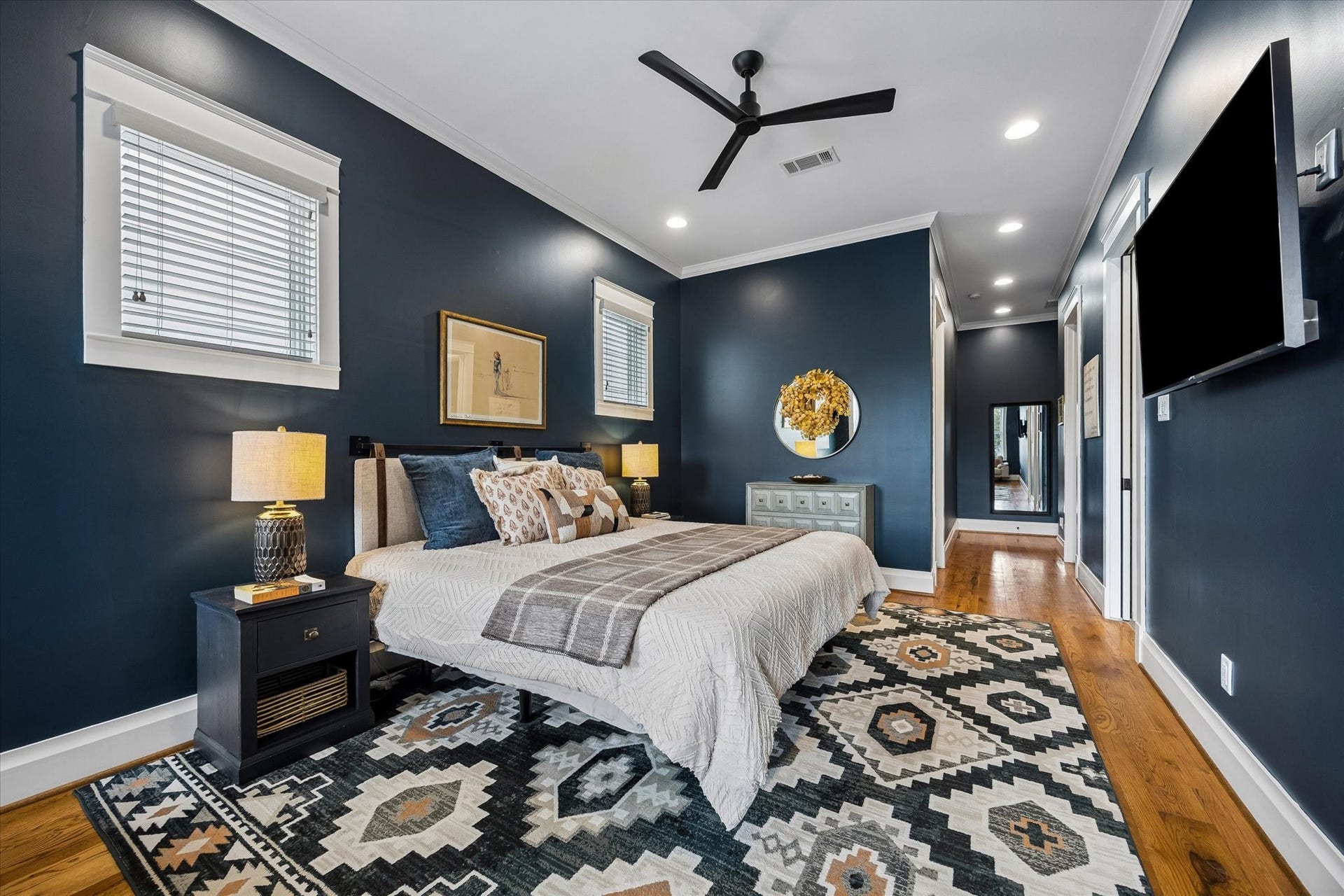 438 W 28th Street, Houston, TX 77008 There's plenty of room to stretch out, relax and make yourself at home in this inviting primary suite. Rich blue walls, beautiful wood floors and modern lighting create a cozy atmosphere, while two custom walk-in closets and a spa-like ensuite add a little everyday luxury.