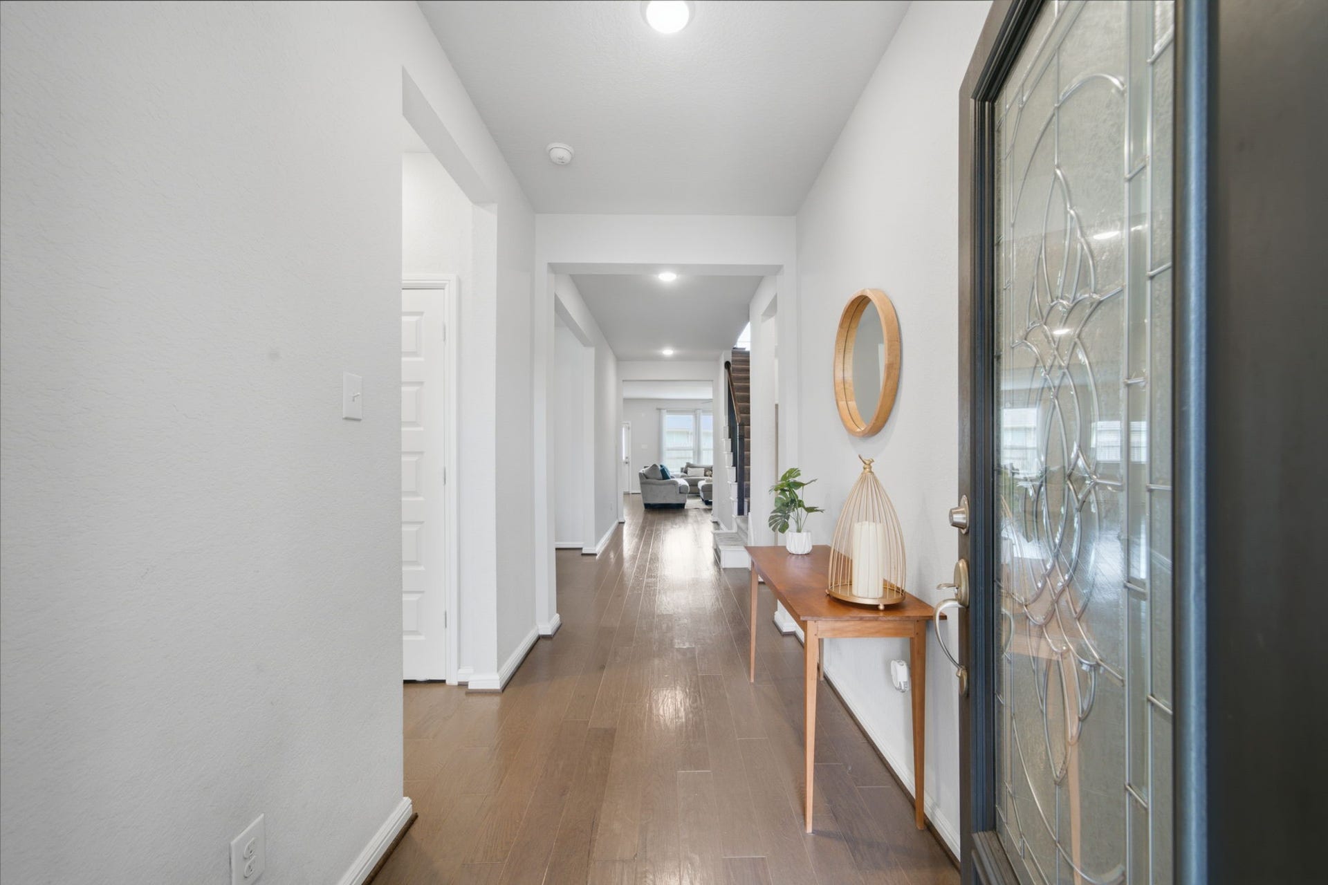 Elegant entryway with sleek wood-look tile, leading to a bright and inviting foyer.