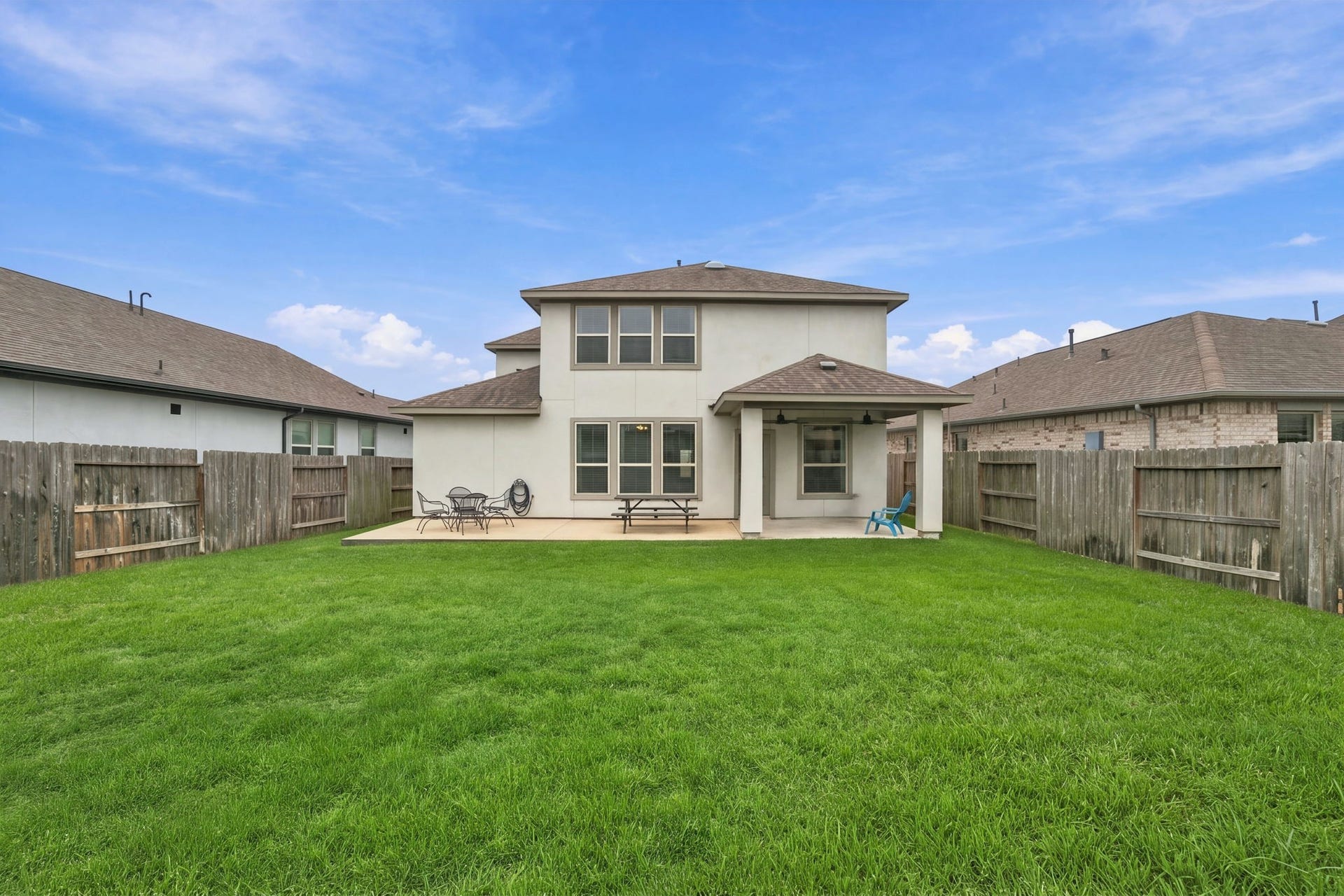 A view of the backyard covered patio and the extended concrete pad area.