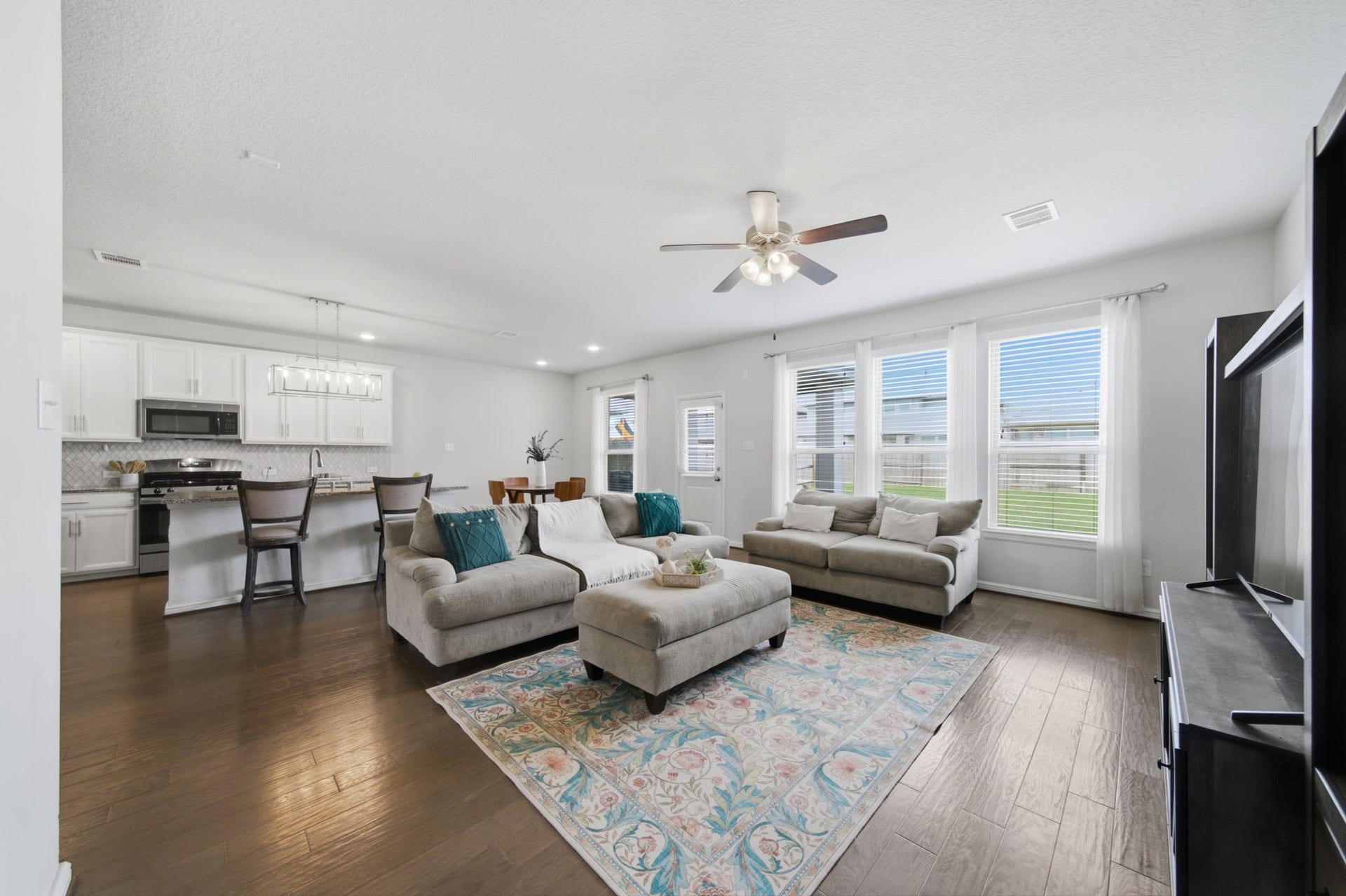 Spacious living area with a wall of windows allowing for plenty of natural light to come in.