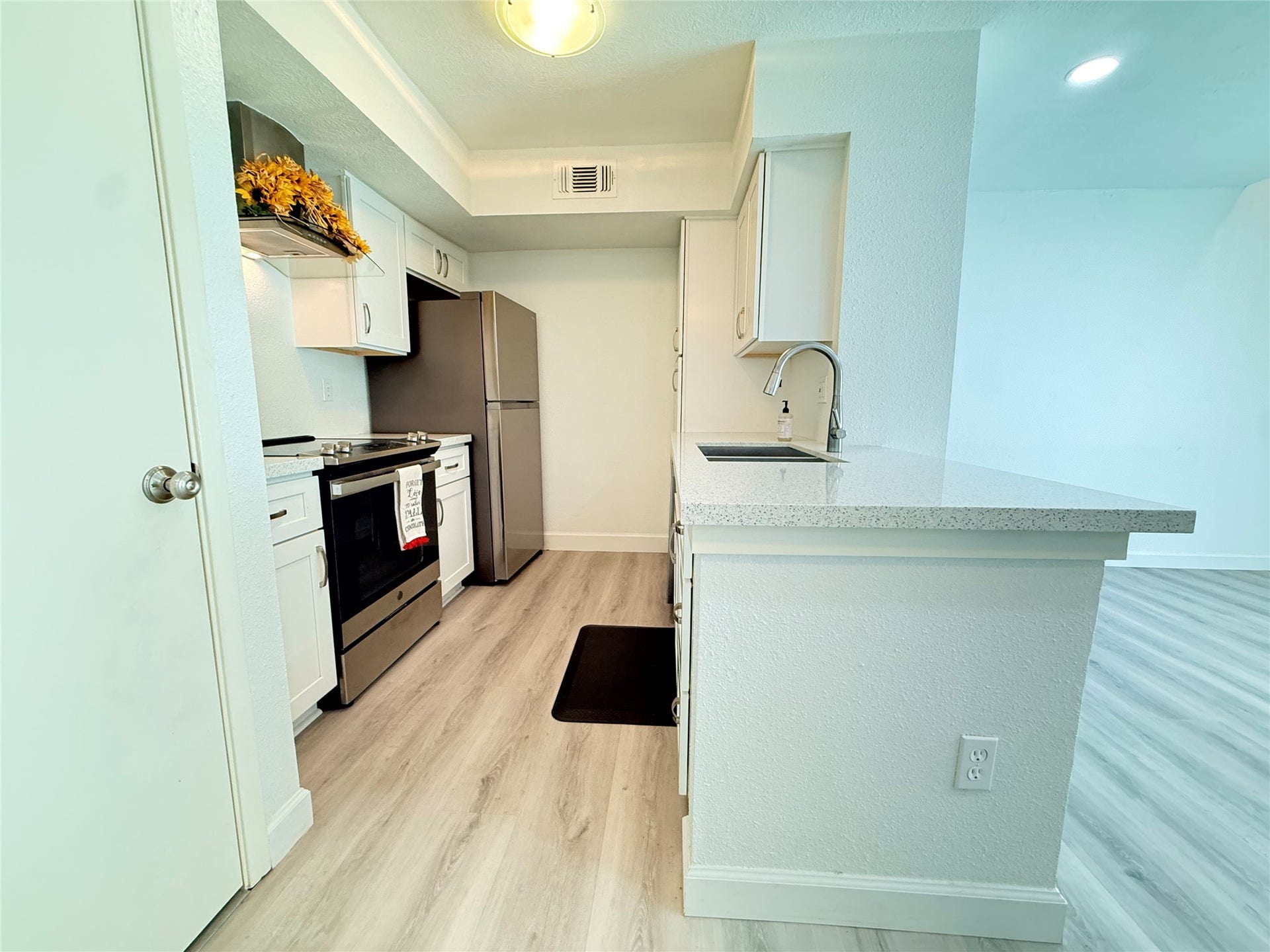 2800 Jeanetta Street, #2402, Houston, TX 77063 Enjoy the open kitchen with new appliances and quartz countertops. Door to left is washer/dryer.