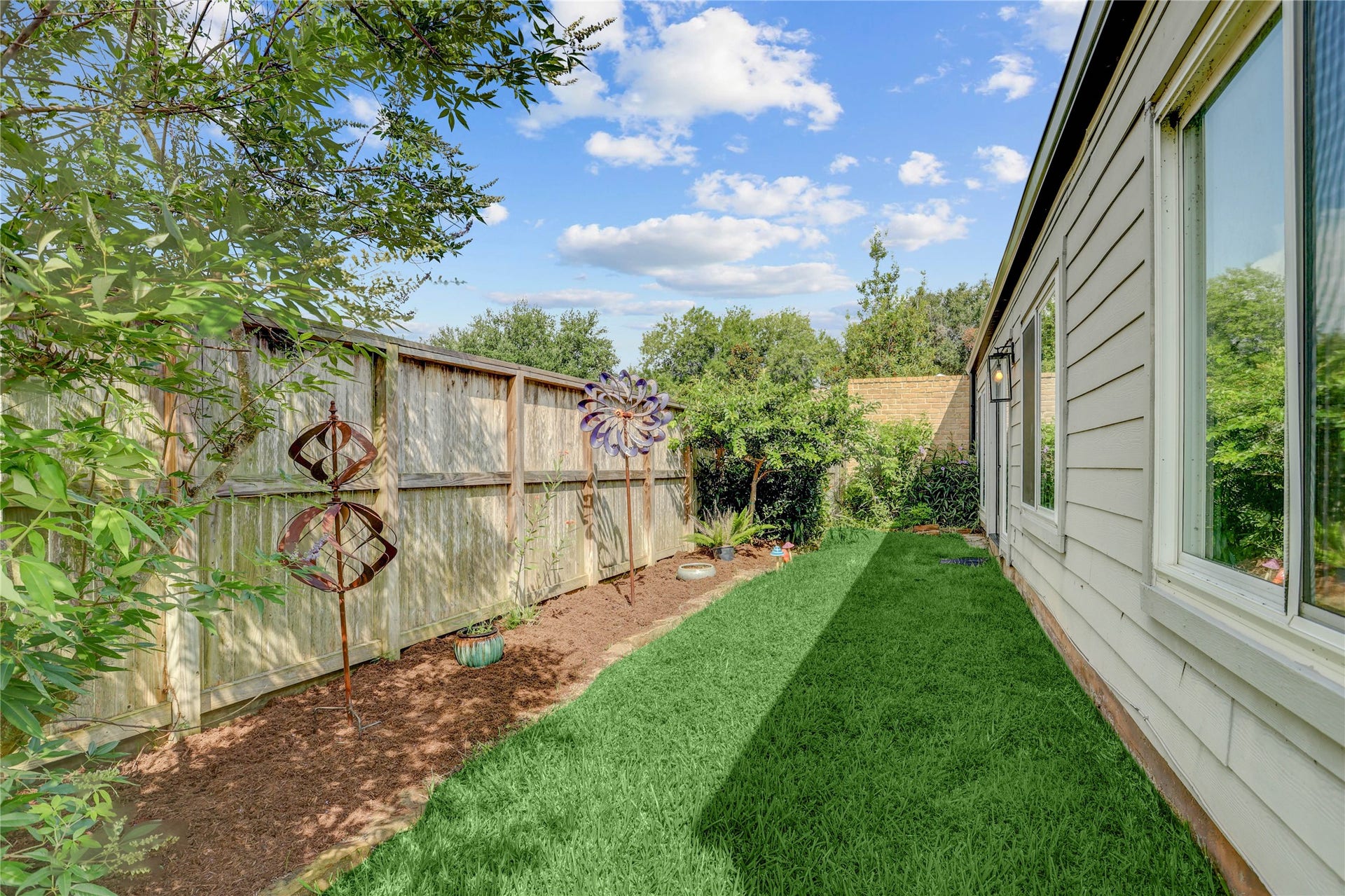3311 Carmel Valley Drive, Missouri City, TX 77459 Private side yard offers a peaceful outdoor retreat with lush green space, mature landscaping and low-maintenance garden beds.