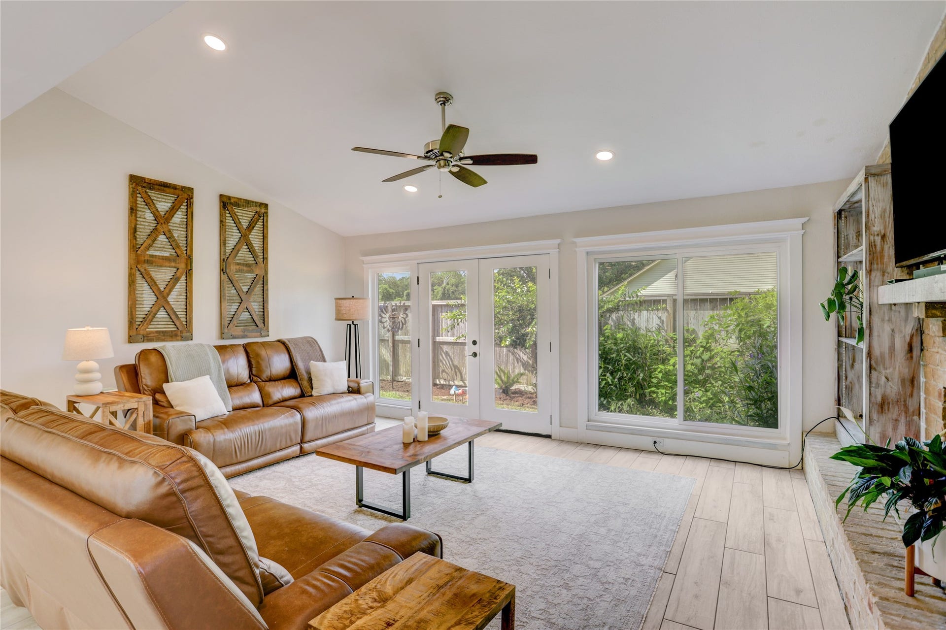 3311 Carmel Valley Drive, Missouri City, TX 77459 Bright and inviting living room featuring abundant light, elegant French Doors, oversize picture windows, recessed lighting and a cozy fireplace.