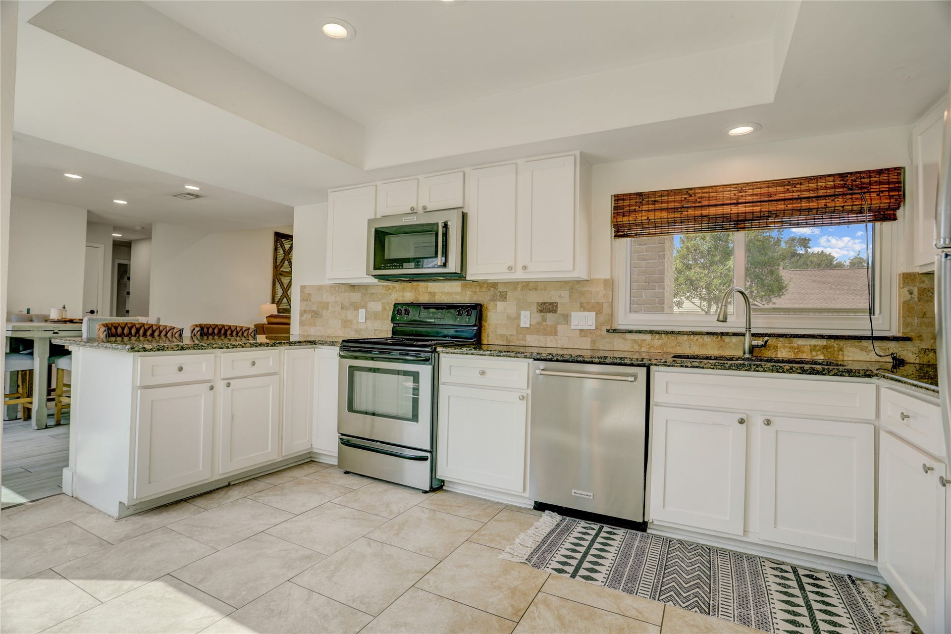 3311 Carmel Valley Drive, Missouri City, TX 77459 Updated kitchen with crisp white cabinets, stainless steel appliances, tile backsplash and generous workspace. Large picture window fills the room with light.
