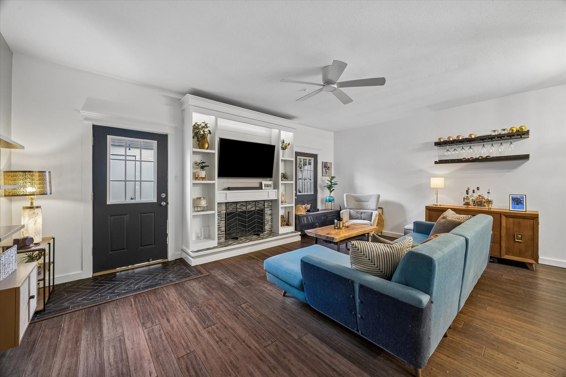 Two doors flank the wood burning fireplace. These doors open to the back patio and two car garage.