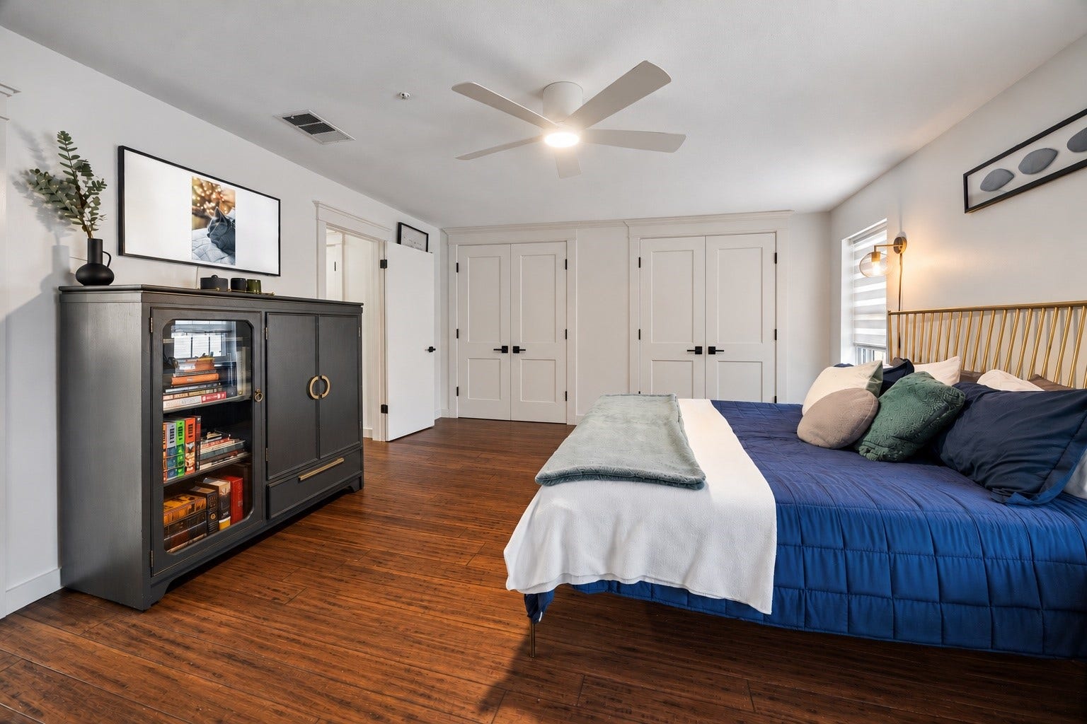 Virtually enhanced photo illustrating how the primary bedroom closet could look with the addition of French-style closet doors. Doors are for illustrative purposes only and are not currently installed.