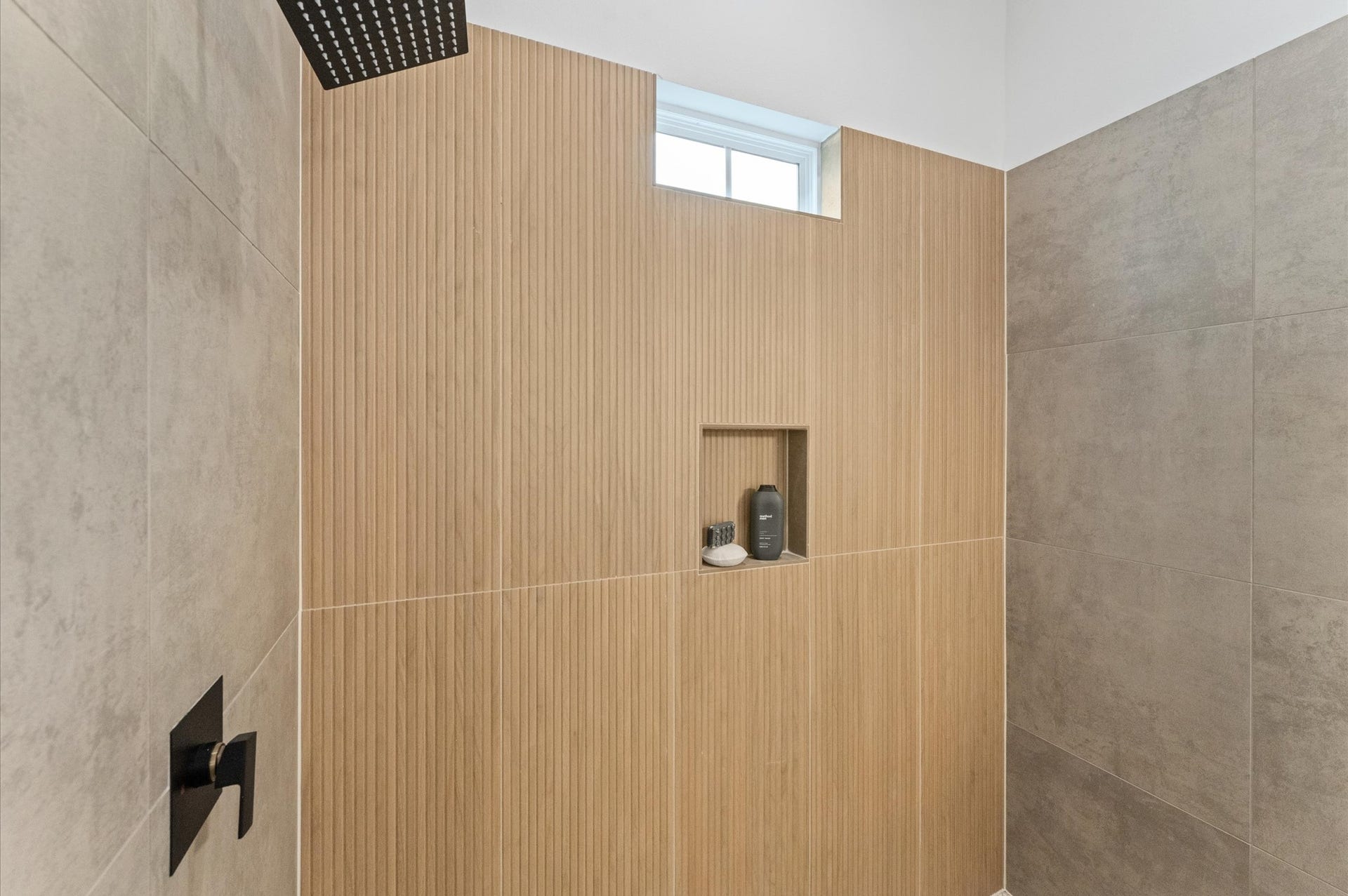 This stylish primary bathroom showcases a spacious walk-in shower framed with sleek glass panels and modern tilework that adds texture and sophistication. A double sink vanity anchors the space with clean lines and ample countertop room, complemented by an abundance of cabinetry that offers both function and flair. Contemporary finishes tie the room together, creating a polished retreat that balances luxury with everyday practicality.
