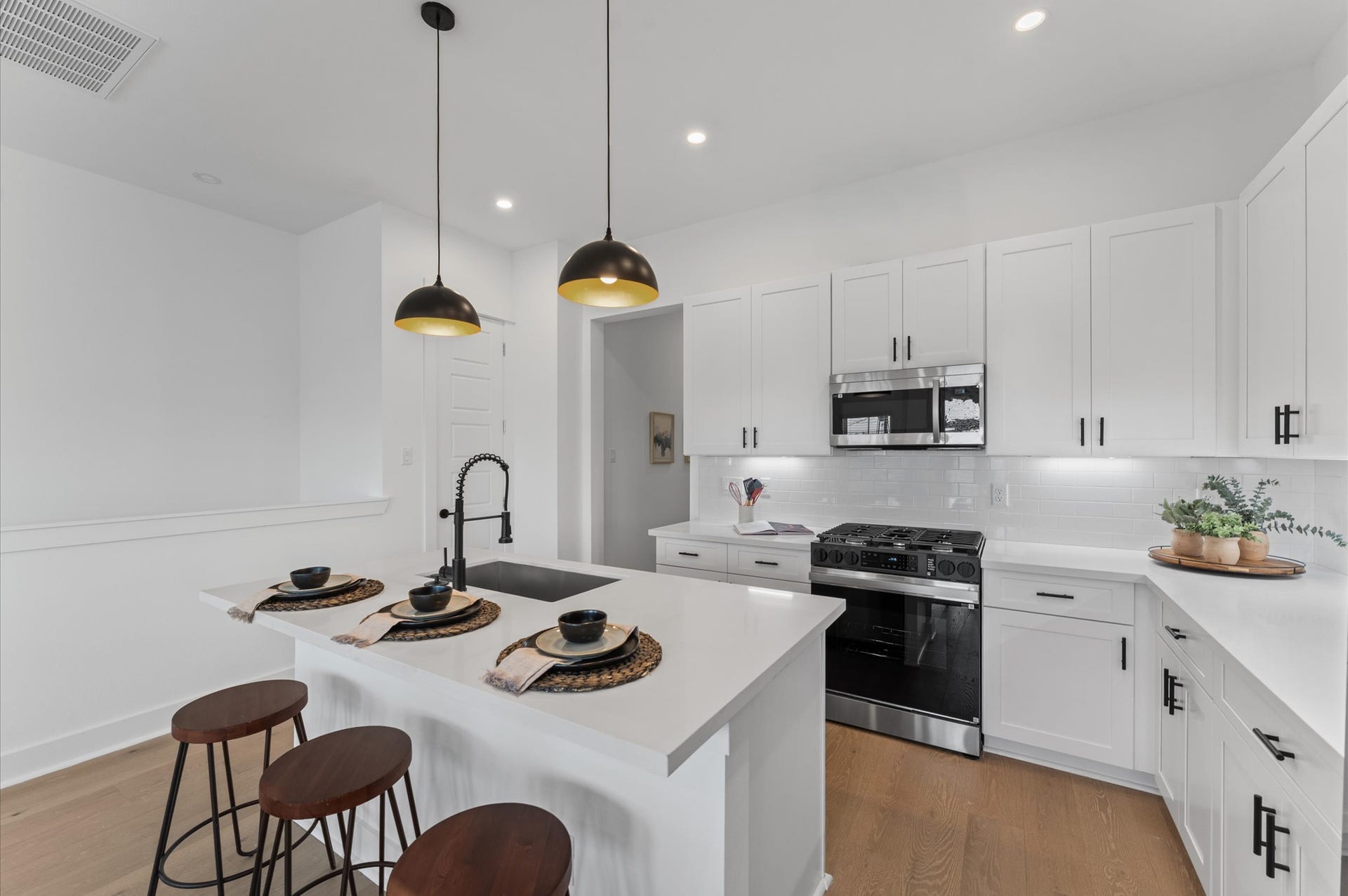 This centrally positioned kitchen island serves as a stylish anchor within the open-concept layout, offering clear sightlines to the dining area, living space, and the balcony beyond. Its placement encourages seamless interaction, whether prepping meals or entertaining guests, while natural light pours in through the nearby windows. The islands sleek design and functional surface make it a hub of activity tying together comfort and sophistication.