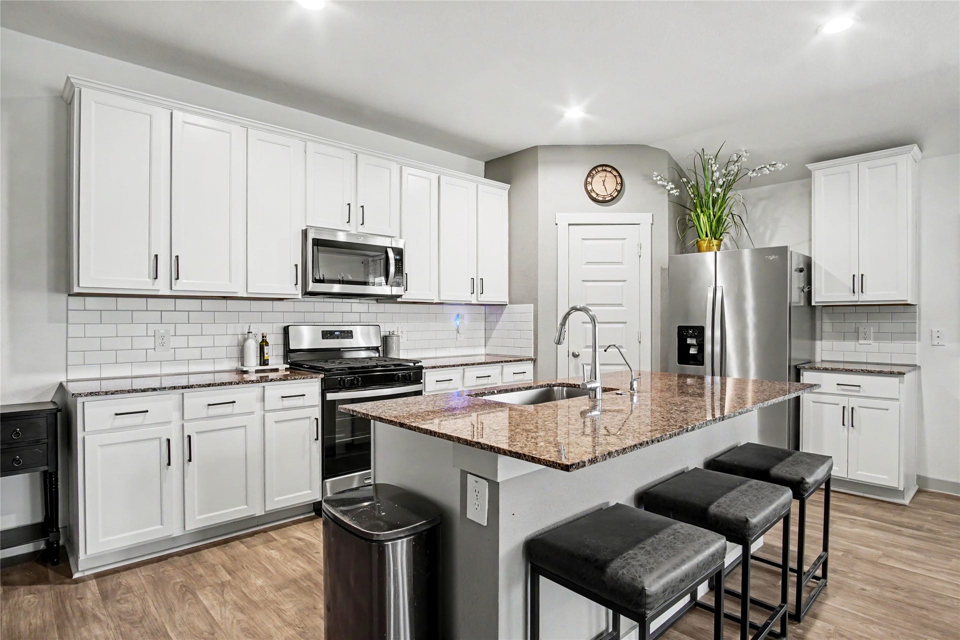 This kitchen is light and bright with white cabinetry, upgraded hardware, gas stove, and granite countertops!  Large, one-basin sink to fit all your pots and pans!