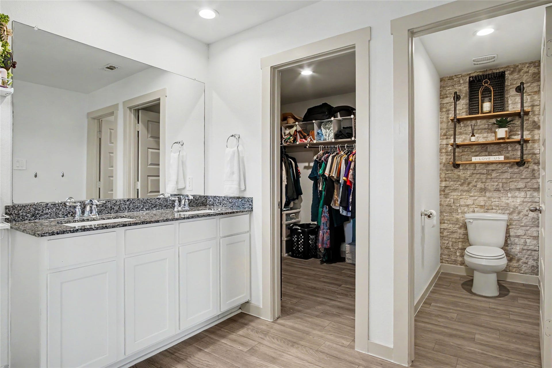 Large primary closet and accent wall are shown here from the primary bathroom.