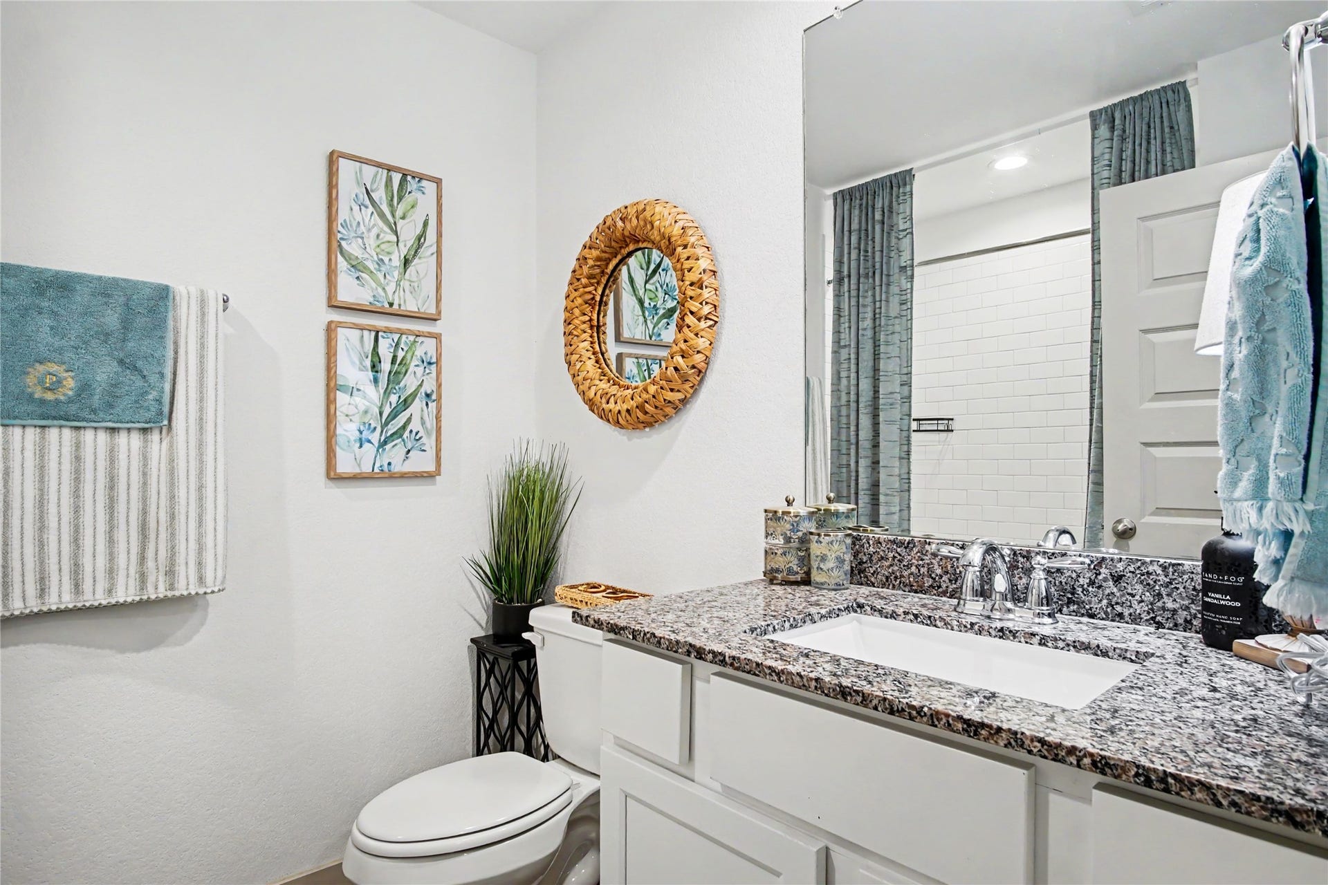Spacious guest bathroom at the front of the home with granite countertops and neutral colors.