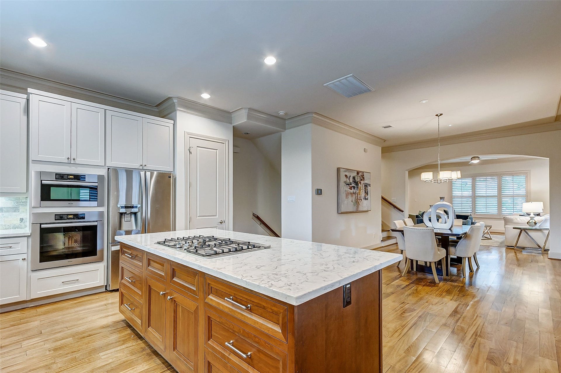 1955 Sheridan Street, Houston, TX 77030 Elevate your entertaining in this stunning home, showcasing a large, modern kitchen with stainless steel appliances and sleek wood flooring.