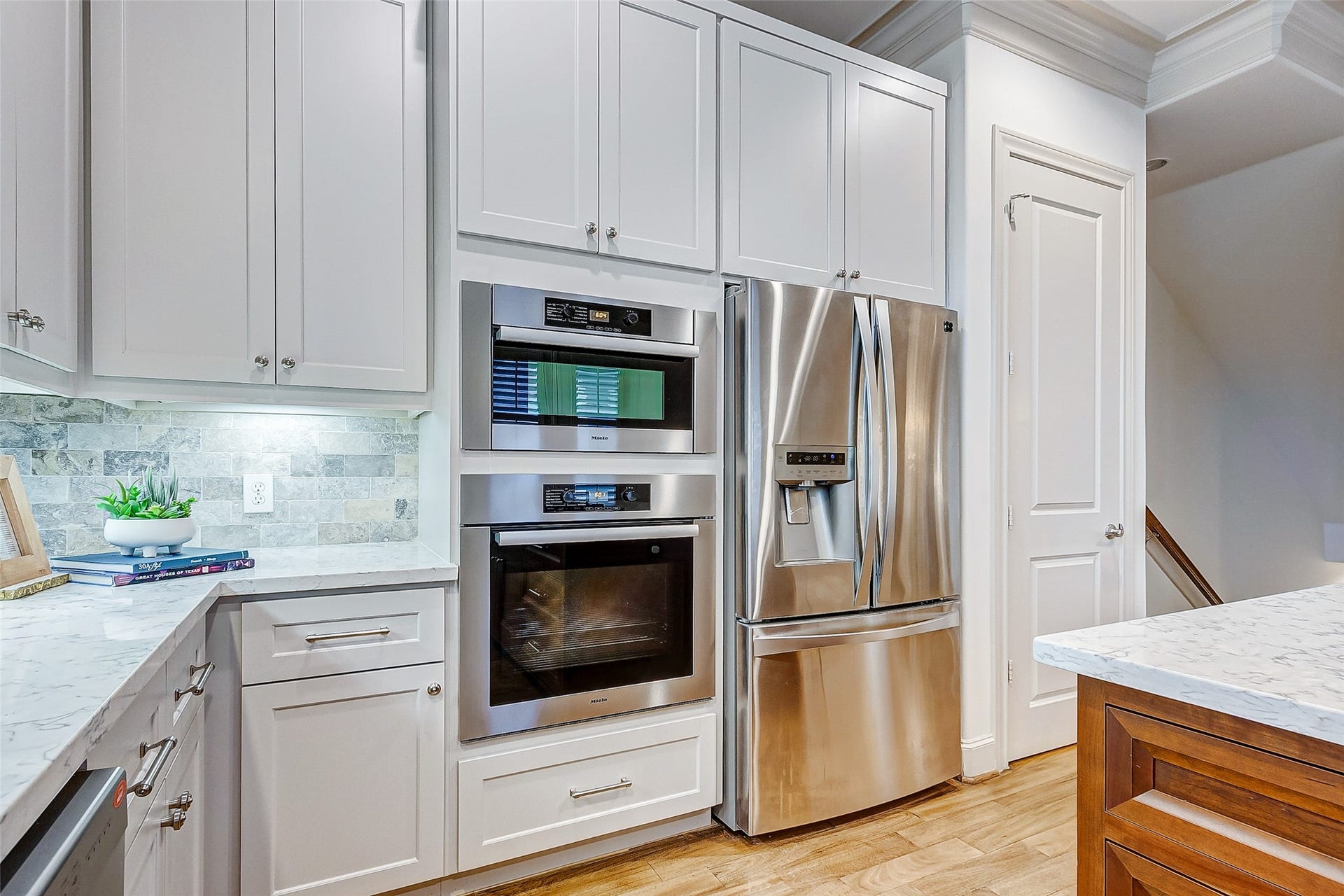 1955 Sheridan Street, Houston, TX 77030 Sleek modern kitchen featuring stainless steel appliances, elegant white cabinetry, and a stylish marble countertop for a sophisticated cooking space.