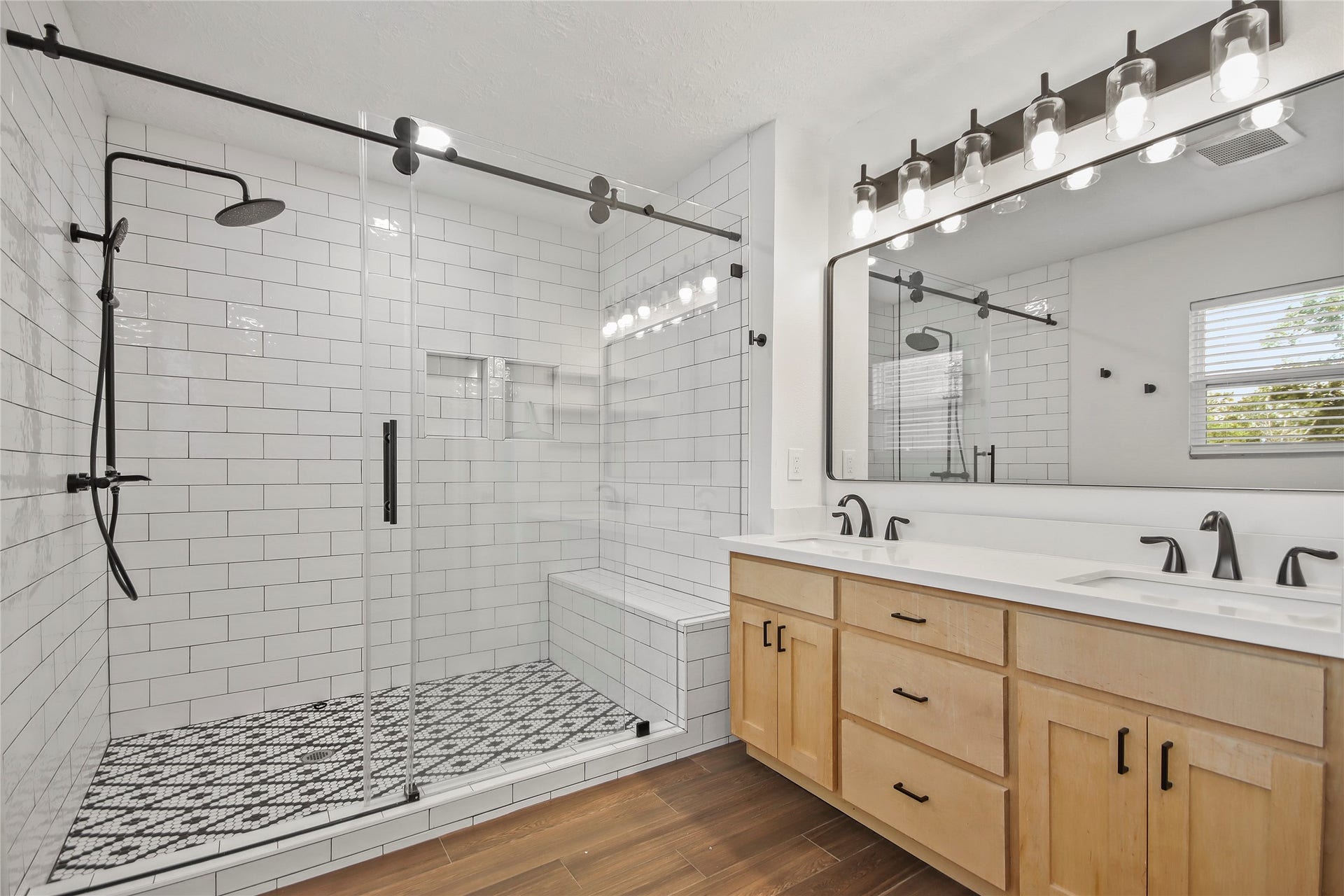 3527 Eula Morgan Road, Katy, TX 77493 The newly renovated ensuite bath features a barn-door glass shower with subway tile, a built-in bench, and a dual vanity with stylish lighting.