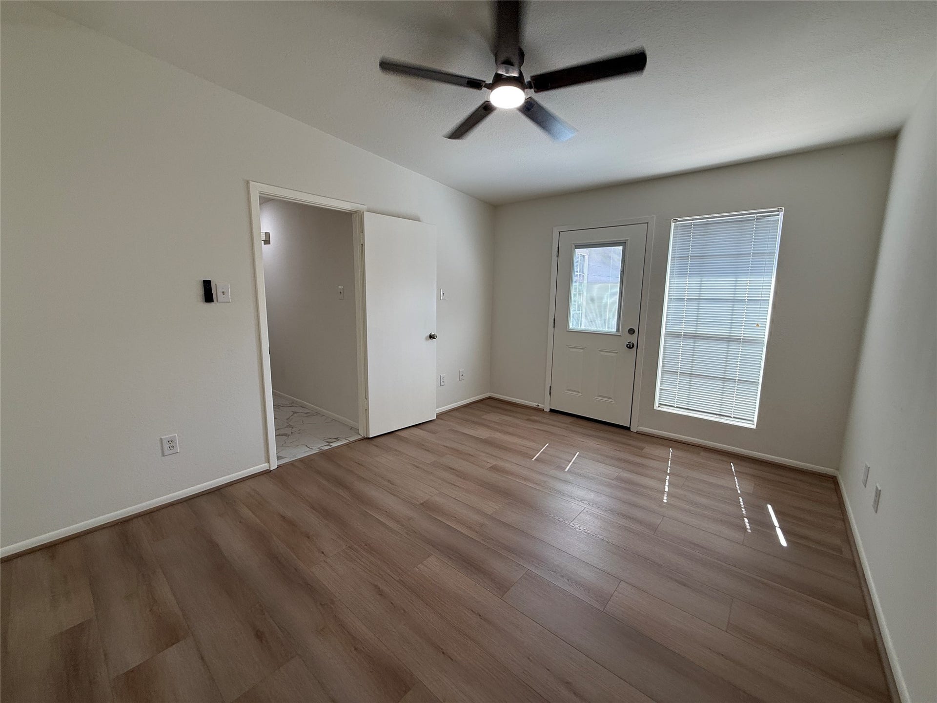 Primary bedroom with new ceiling fan, and door to private patio.