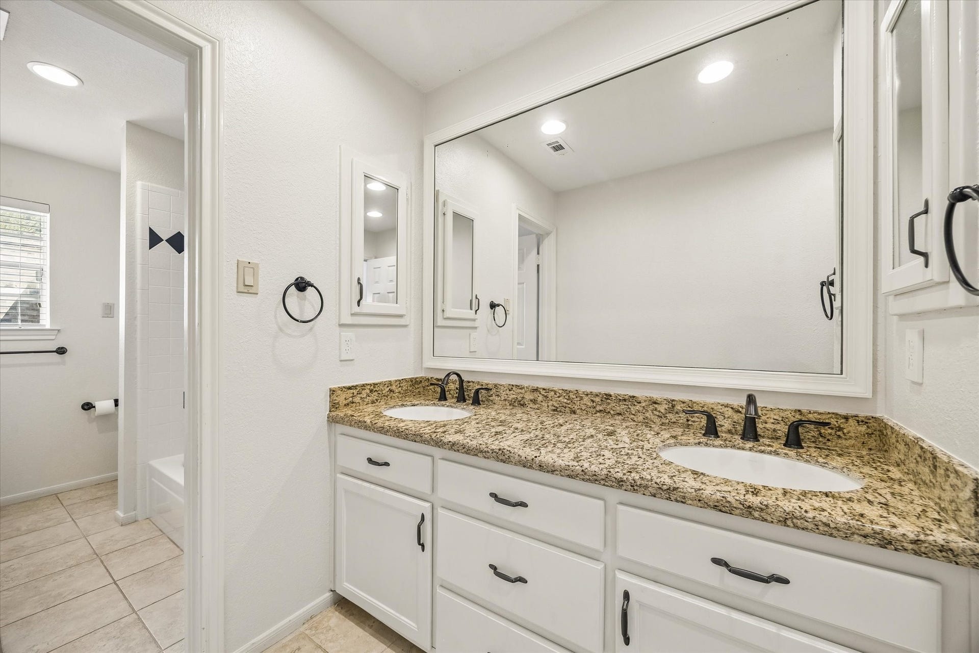 30 SAINT SIMONS COURT, Sugar Land, TX 77479 THE DUAL-SINK VANITY PROVIDES GRANITE COUNTERTOPS, AMPLE STORAGE, AND CONVENIENT SHARED BATHROOM SPACE.