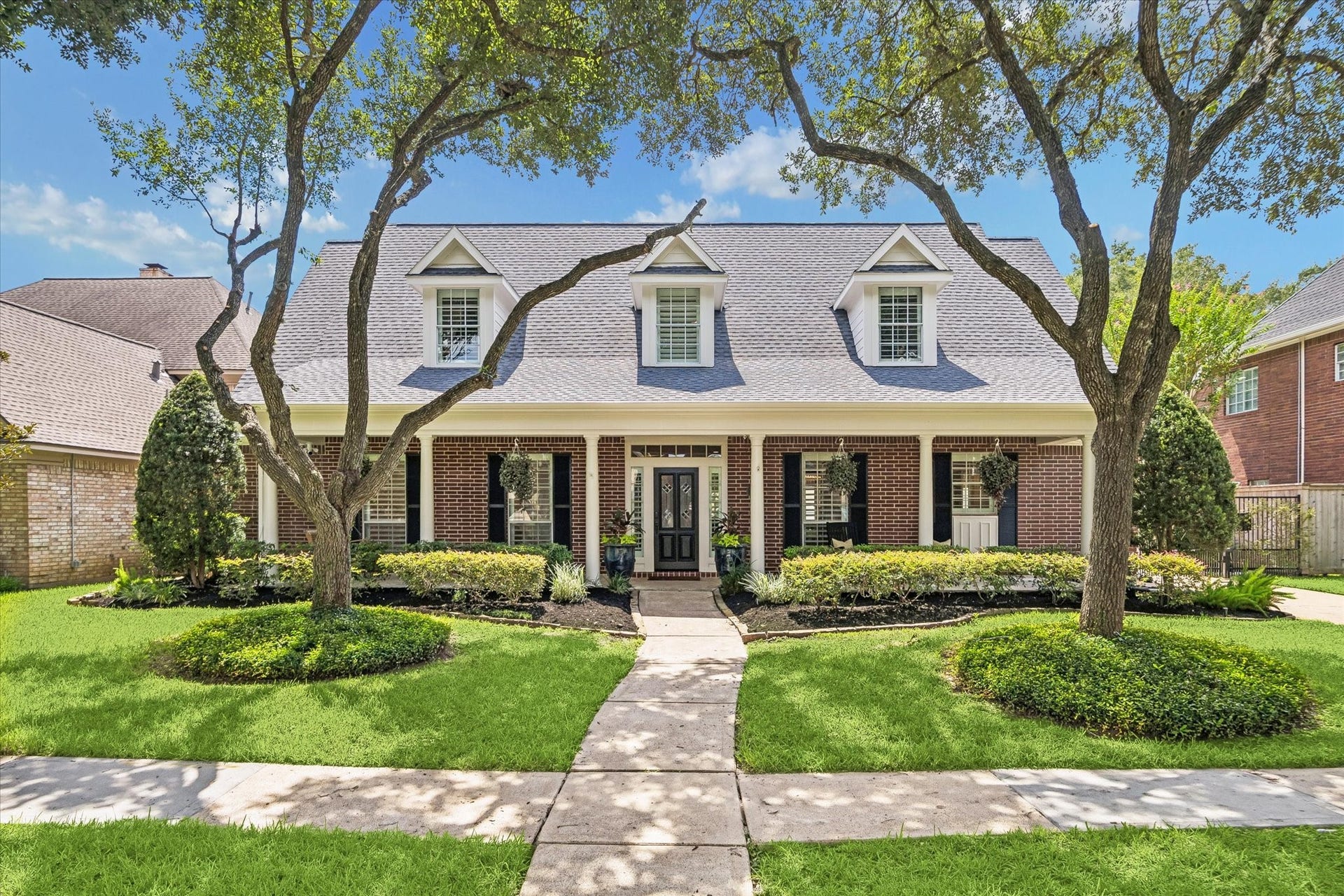 30 SAINT SIMONS COURT, Sugar Land, TX 77479 CLASSIC BRICK EXTERIOR WITH A WIDE COVERED FRONT PORCH, DORMER WINDOWS, AND MATURE SHADE TREES.