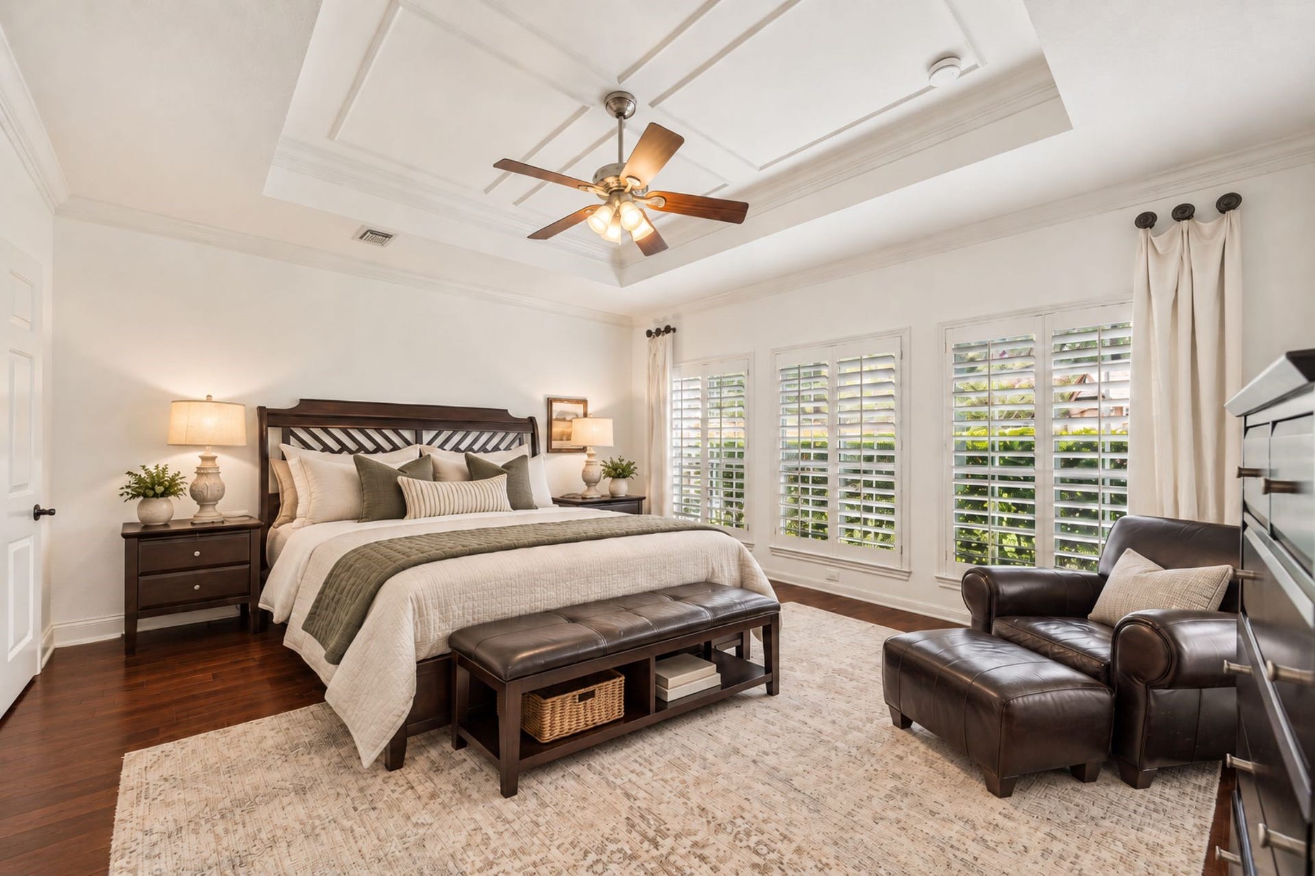 30 SAINT SIMONS COURT, Sugar Land, TX 77479 THE FIRST-FLOOR PRIMARY SUITE FEATURES HARDWOOD FLOORING, A DECORATIVE TRAY CEILING, AND A WALL OF WINDOWS WITH PLANTATION SHUTTERS. **Virtually Staged.