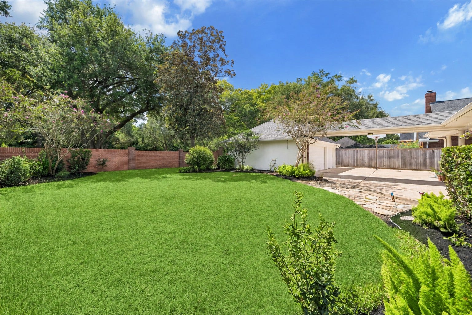 30 SAINT SIMONS COURT, Sugar Land, TX 77479 BEAUTIFULLY LANDSCAPED BACKYARD FEATURING A SPACIOUS LAWN, MATURE SHADE TREES, AND CONVENIENT ACCESS TO THE DETACHED GARAGE AND COVERED PARKING.