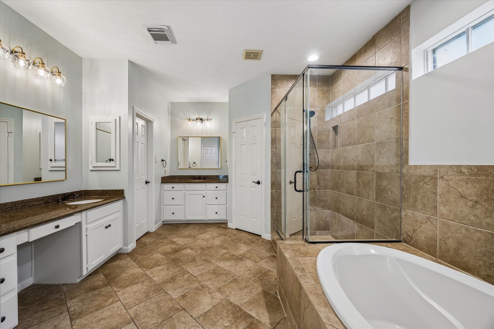30 SAINT SIMONS COURT, Sugar Land, TX 77479 THE SPACIOUS PRIMARY BATH OFFERS AN EXTENDED VANITY, A JETTED TUB, AND A SEPARATE GLASS-ENCLOSED SHOWER.
