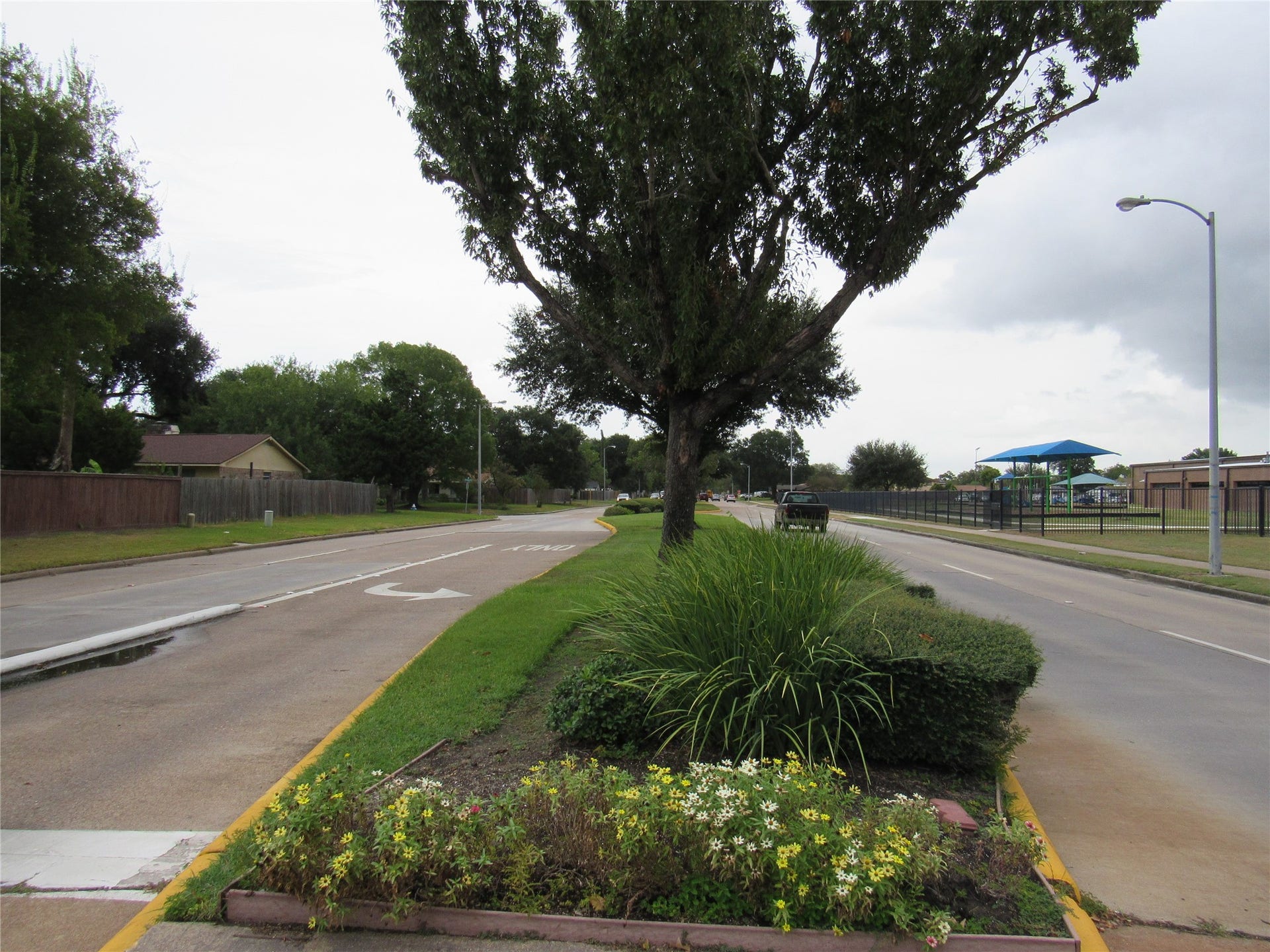 Divided and landscapped 4=lane West Road (main road) with side walks.