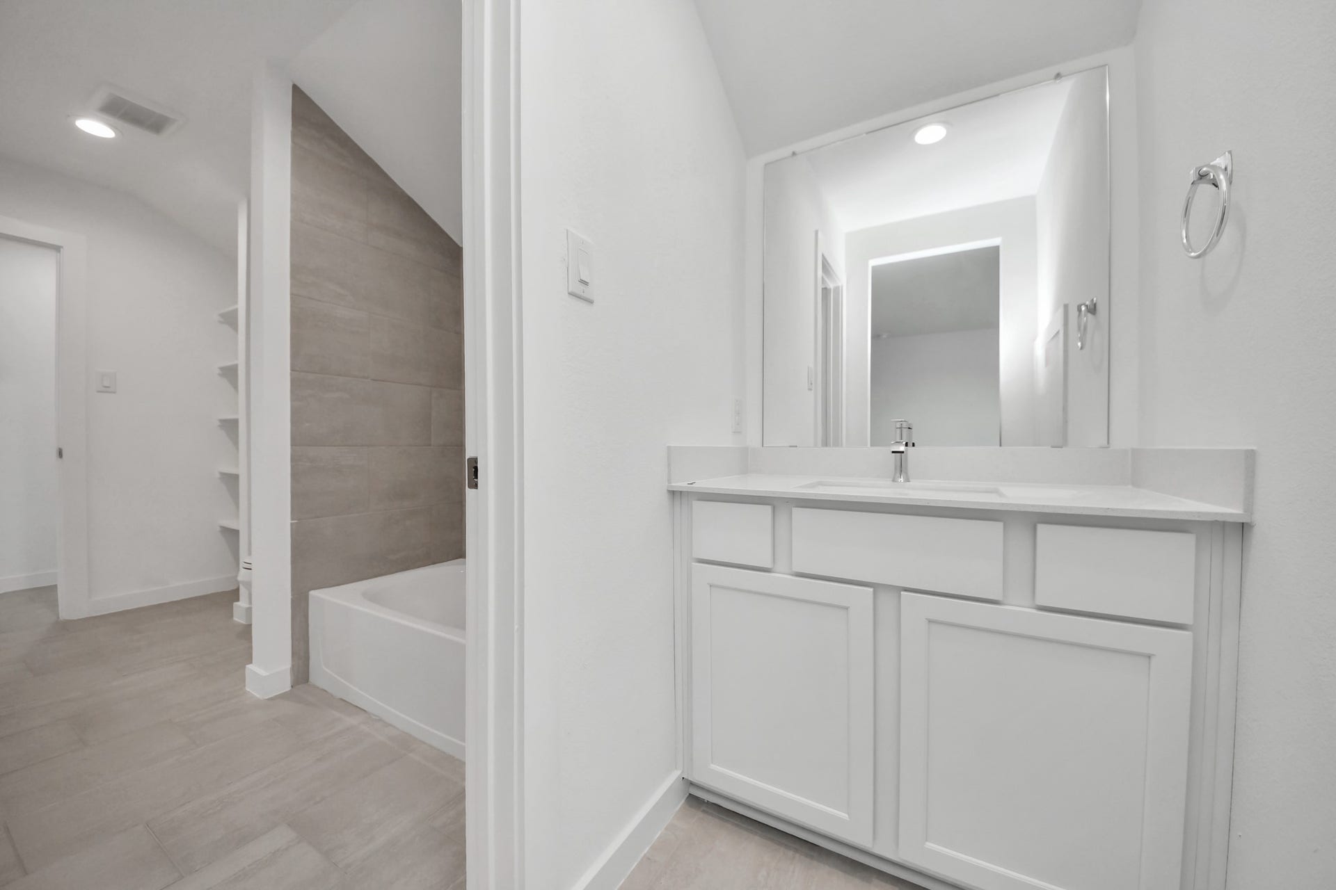 3072 Spoolwood Trail, Magnolia, TX 77355 Experience convenience in the secondary bathroom, designed for Jack and Jill arrangements, now with a separate vanity area. This well-appointed space showcases stylish tile flooring, a bath/shower combo with an elegant tile surround, and light-stained wood cabinets. The beautiful light countertop adds a touch of sophistication, combining functionality and aesthetics seamlessly.