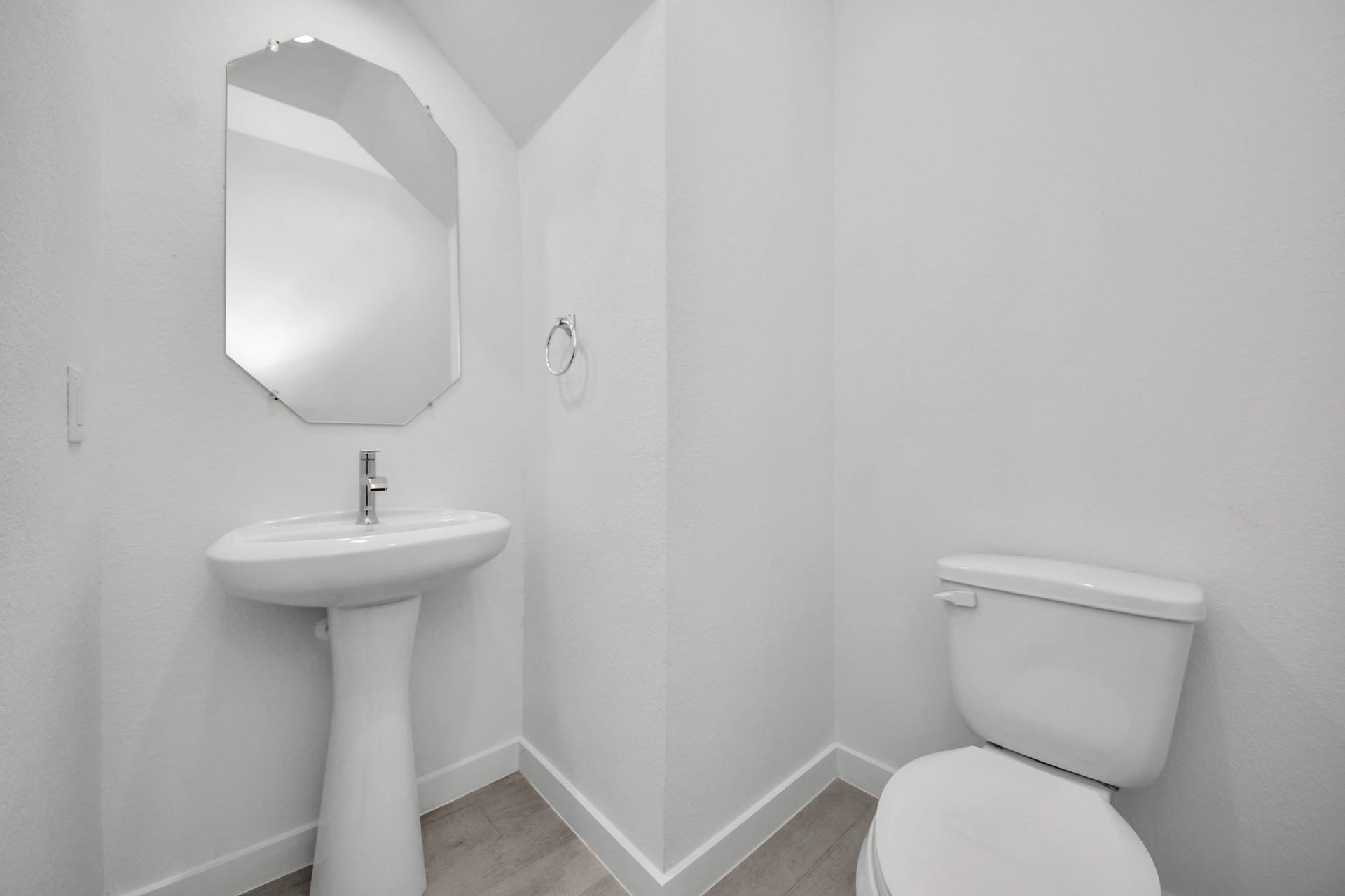 3072 Spoolwood Trail, Magnolia, TX 77355 This half bathroom features a stylish pedestal sink, modern hardware, and bright recessed lighting, creating a sleek and inviting space.
